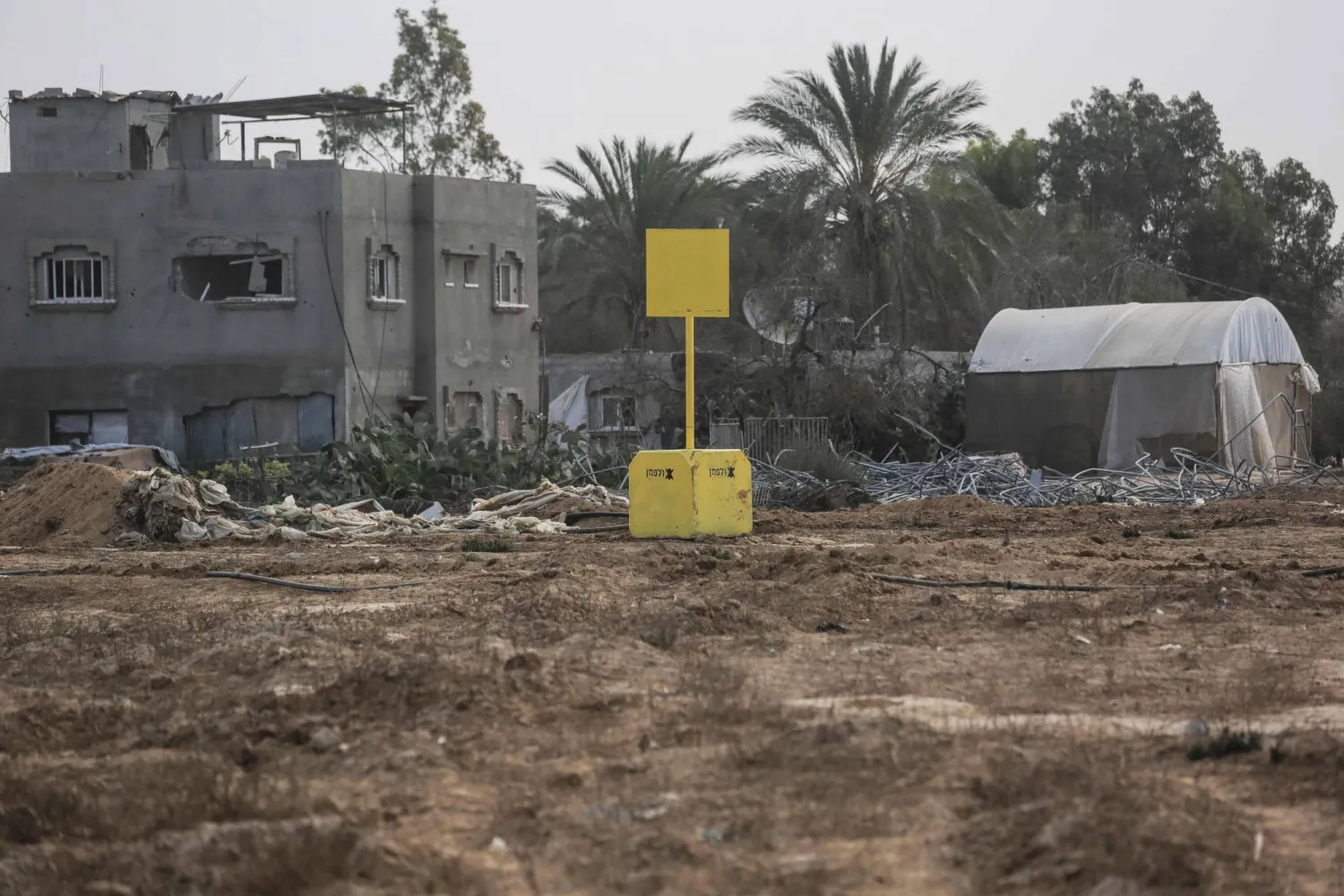 A general view of a concrete block (back) marking the "yellow line" drawn by the Israeli military in Bureij, central Gaza Strip, on November 4, 2025. (AFP)