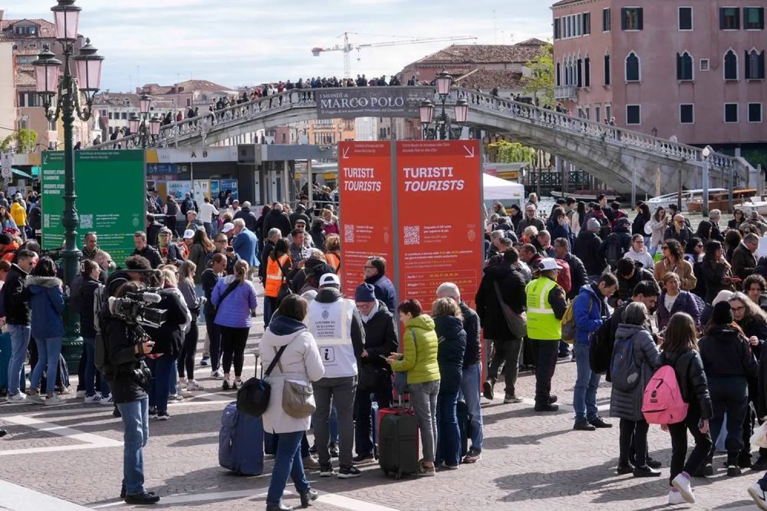 Stewards check tourists QR code access outside the main train station in Venice, Italy, on April 25, 2024. (AP)