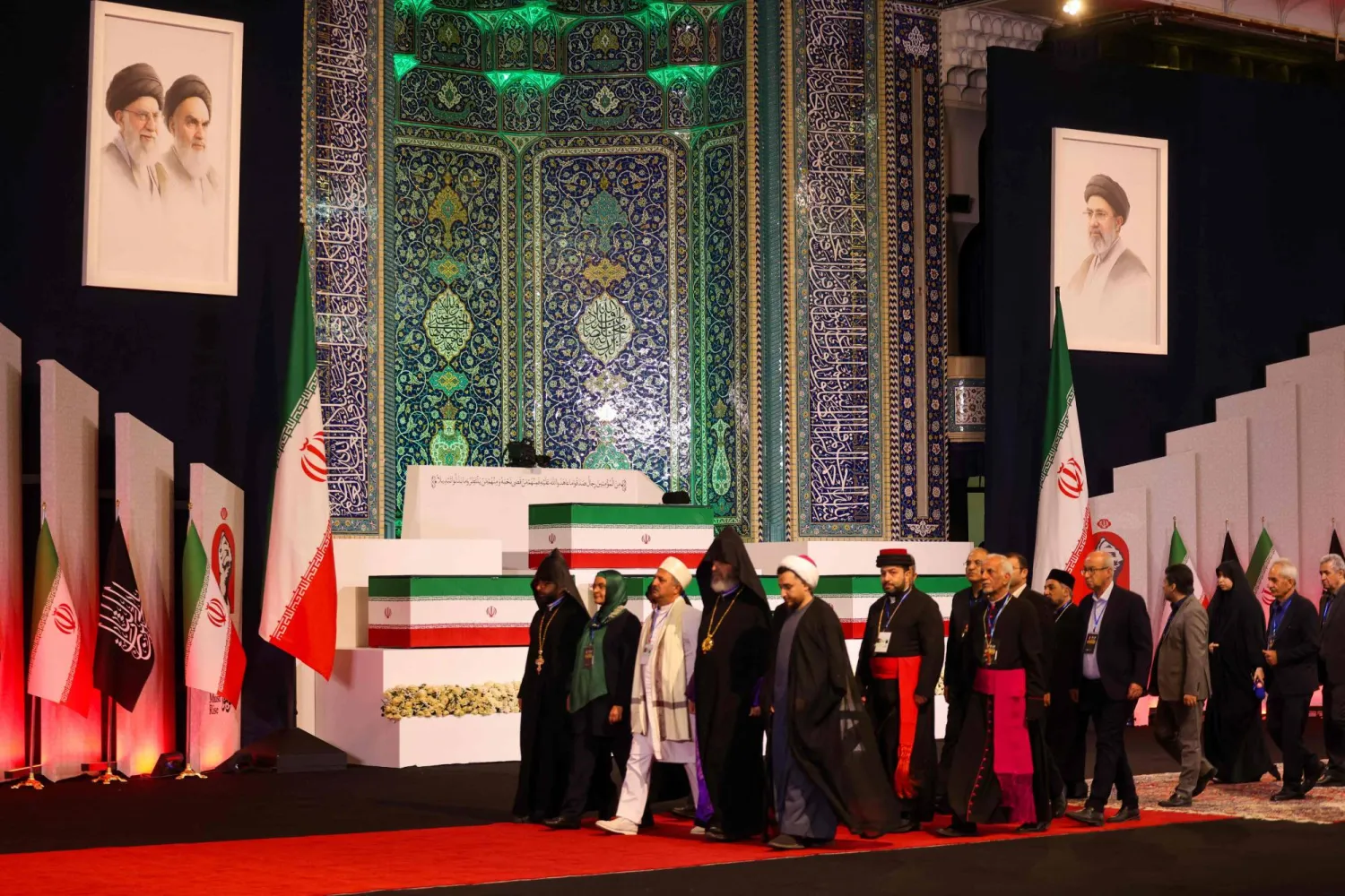 مسؤولون محليون وأجانب يسيرون أمام نعوش المرشد الإيراني علي خامنئي وأفراد عائلته في طهران (أ.ف.ب)