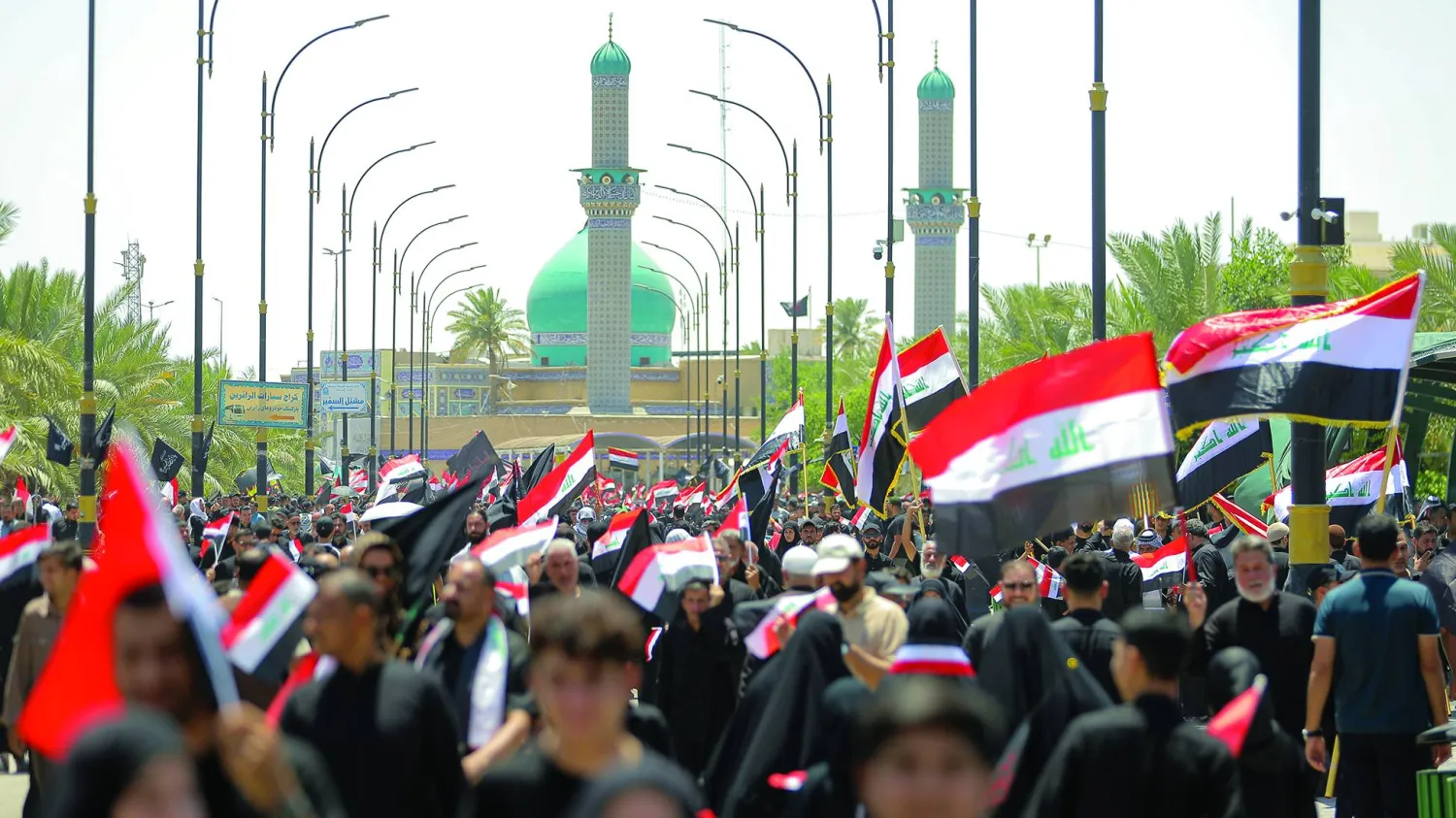 أنصار رجل الدين مقتدى الصدر يلوّحون بالعلم العراقي خلال مظاهرة دعماً لإجراءات الحكومة العراقية لمكافحة الفساد، في النجف، أمس الجمعة. (أ.ب)