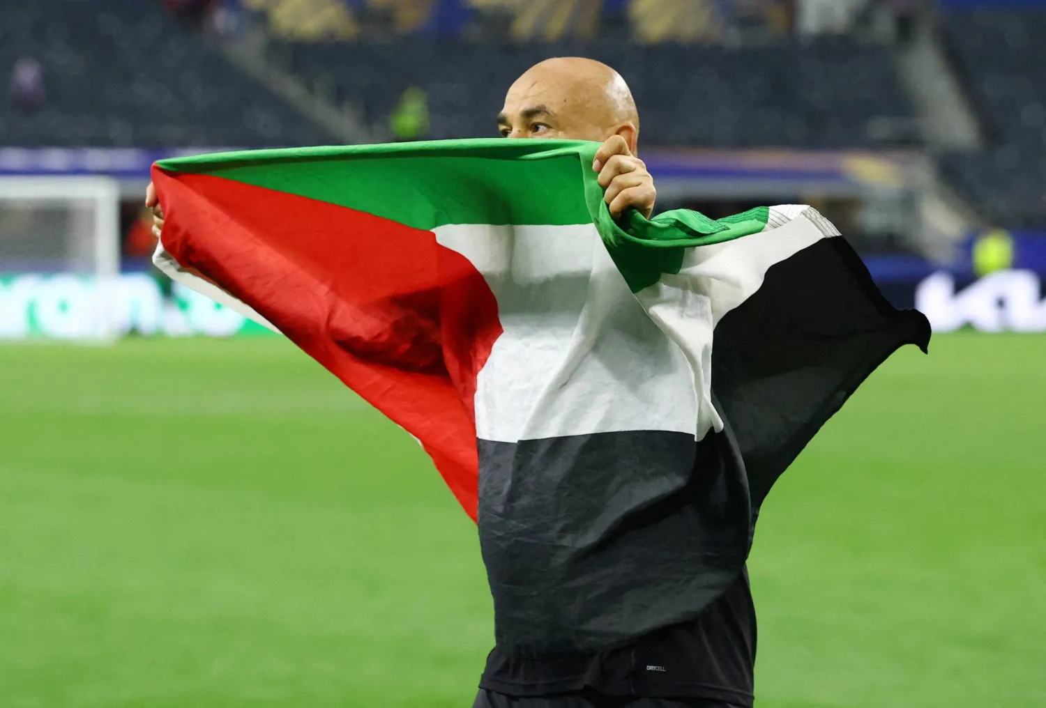 حسام حسن مدرب منتخب مصر يحتفل بعلم فلسطين بعد الفوز على أستراليا (رويترز)