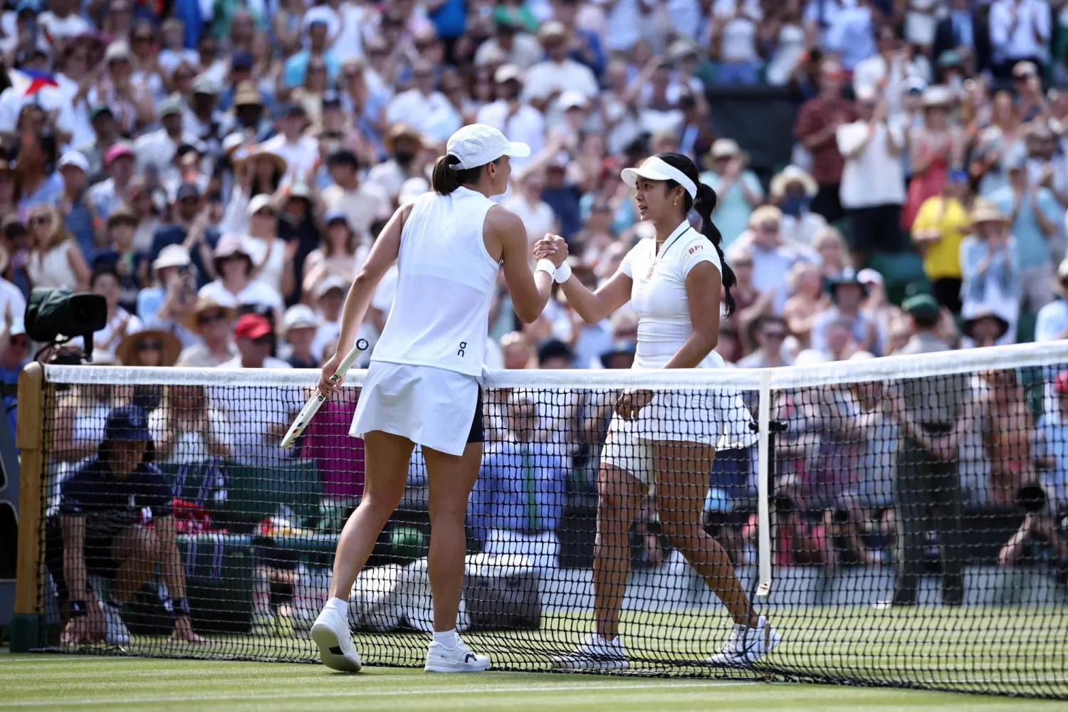Philippines' Alexandra Eala (R) is congratulated by Poland's Iga Swiatek for winning their women's singles third round tennis match on the sixth day of the 2026 Wimbledon Championships at The All England Lawn Tennis and Croquet Club in Wimbledon, southwest London, on July 4, 2026. (Photo by Henry NICHOLLS / AFP) 