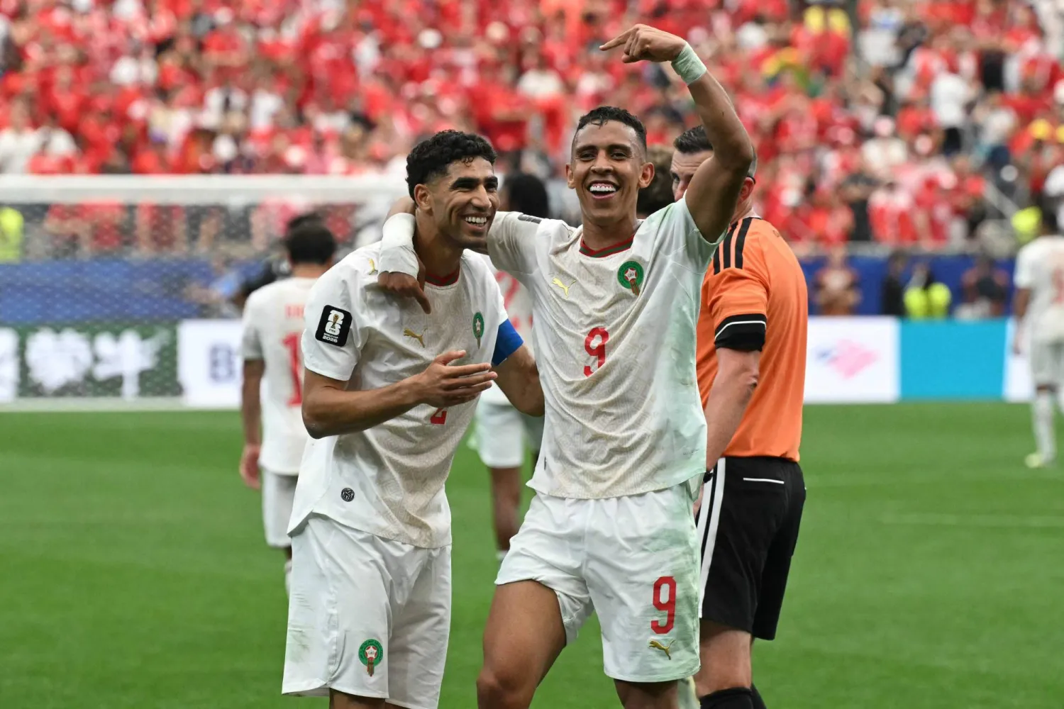 سفيان رحيمي يحتفل مع أشرف حكيمي بعد تسجيل الهدف الثالث للمغرب (أ.ف.ب)
