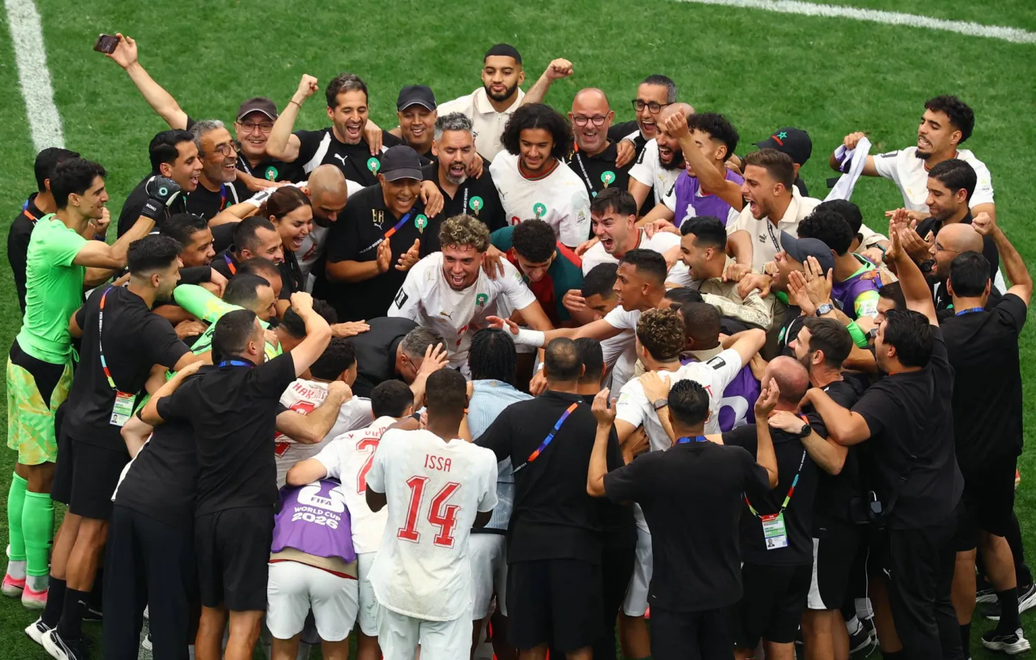 لاعبو المغرب يحتفلون بعد التأهل إلى ربع النهائي (رويترز)
