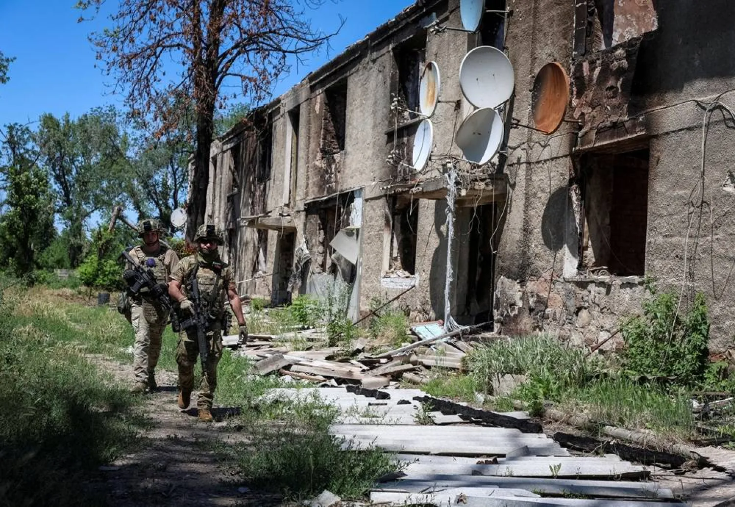 Servicemen of the consolidated Brigade "Khyzhak" of the Ukrainian Patrol Police Department walk near a destroyed apartment building as they take part in a mission to protect a road from Russian drones between frontline towns of Druzhkivka and Kostiantynivka, amid Russia's attack on Ukraine, in Donetsk region, Ukraine June 24, 2026. (Reuters)