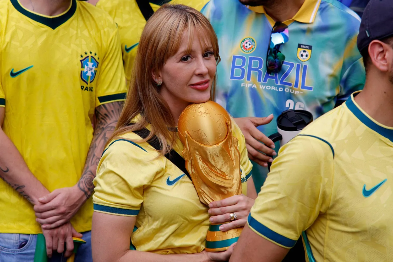مشجعة برازيلية تحمل كأس العالم وتساند منتخب بلادها (أ.ف.ب)