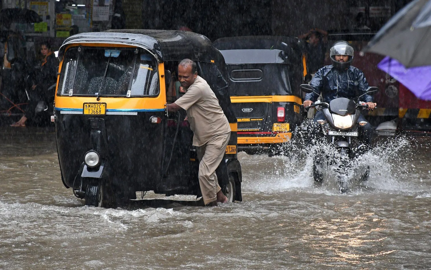 04 July 2026, India, Mumbai: A driver pushes his auto rickshaw (L) on a flooded street after a heavy rain in Mumbai. Photo: Ashish Vaishnav/SOPA Images via ZUMA Press Wire/dpa