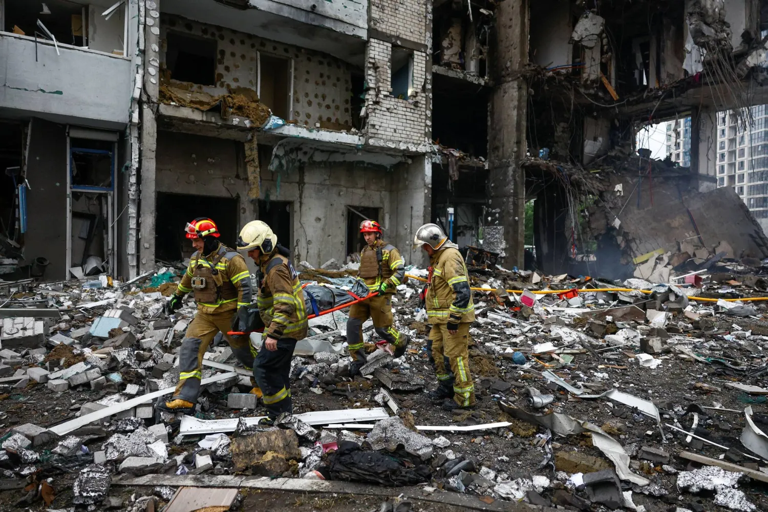 Rescuers carry the body of a resident found under debris inside an apartment building, which was hit during Russian missile and drone strikes, amid Russia's attack on Ukraine, in Kyiv, Ukraine, July 6, 2026. REUTERS/Valentyn Ogirenko