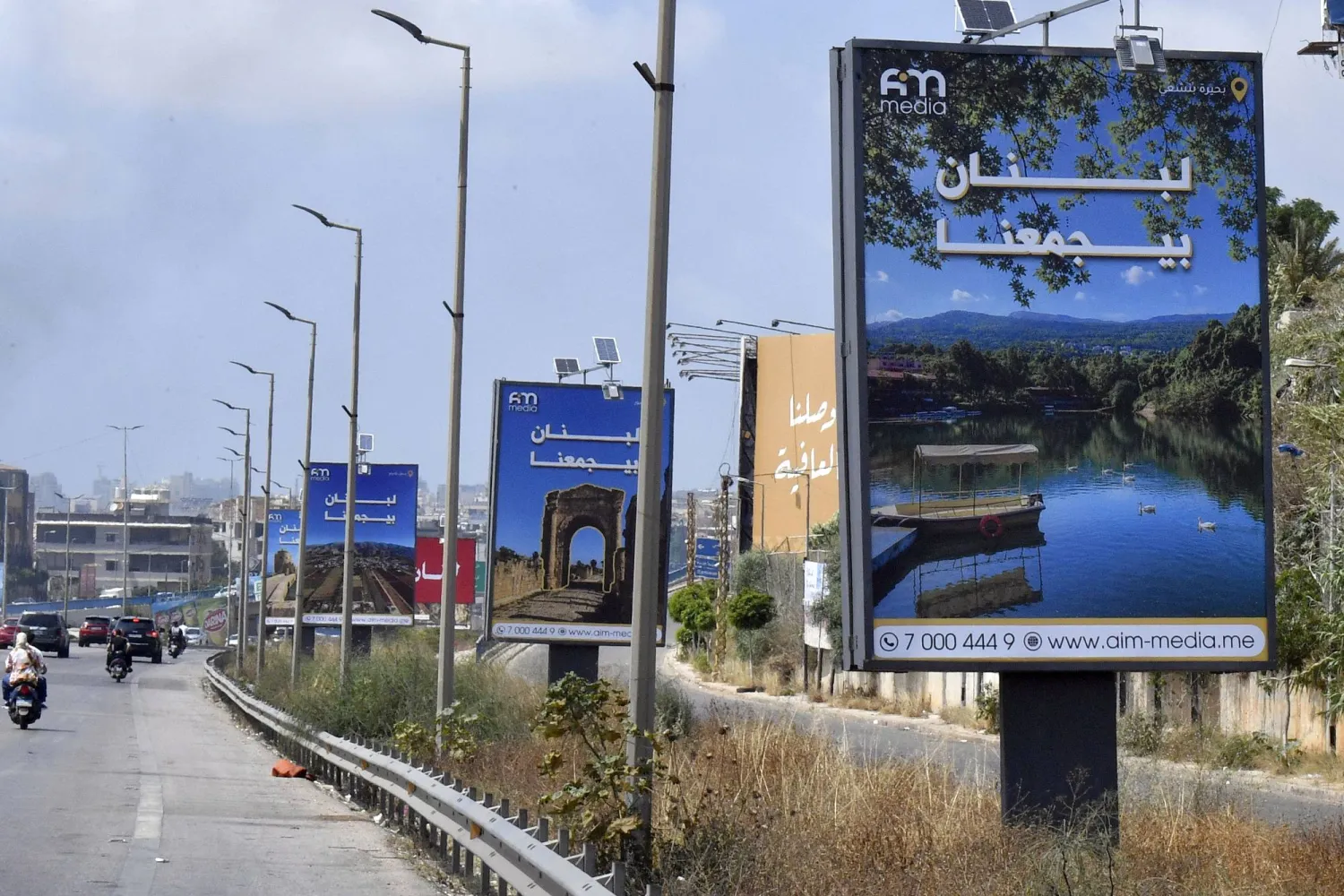 لوحات إعلانية تحمل عبارة «لبنان يجمعنا» رفعت على الطريق المؤدي إلى المطار في بيروت وذلك بعد بدء وقف إطلاق النار بين إسرائيل و«حزب الله» (إ.ب.أ)