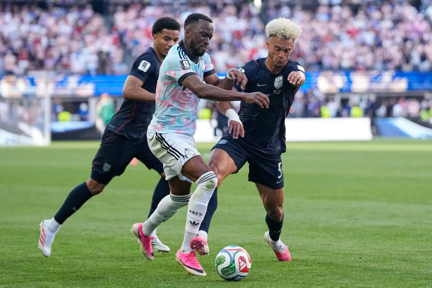 Belgium's Dodi Lukebakio (14) battles for the ball with United States' Antonee Robinson (5) during the World Cup round of 16 soccer match between the United States and Belgium in Seattle, Monday, July 6, 2026. (AP) 
