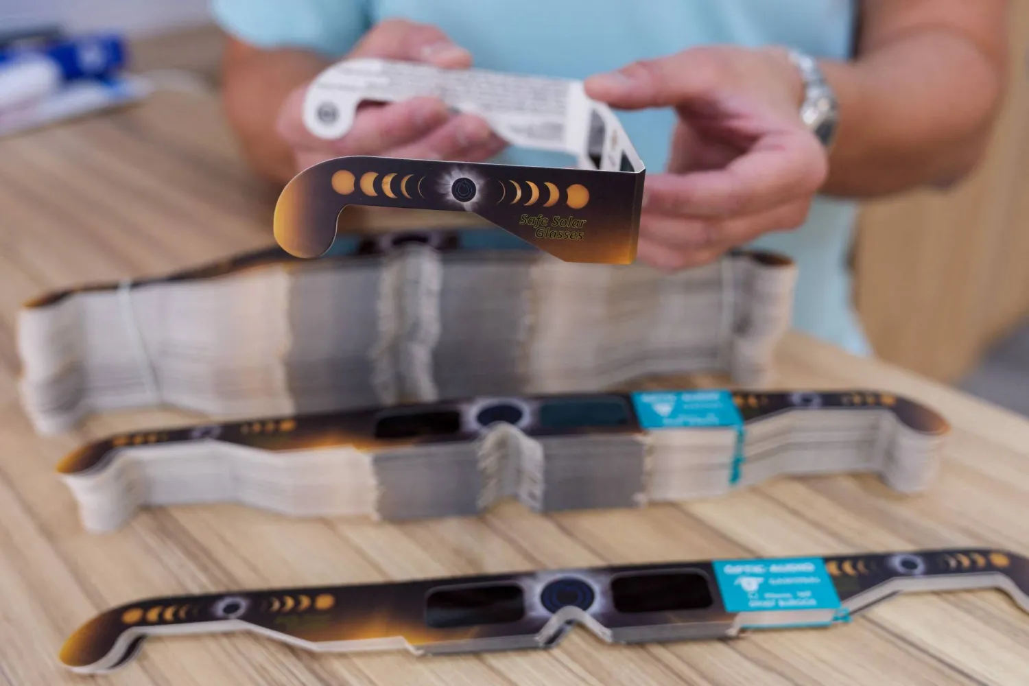  A man holds eclipse-viewing glasses that are certified to the ISO 12312-2:2015 international safety standard, which specifies requirements for the direct observation of the sun, in a store in Burgos on July 2, 2026. (AFP) 