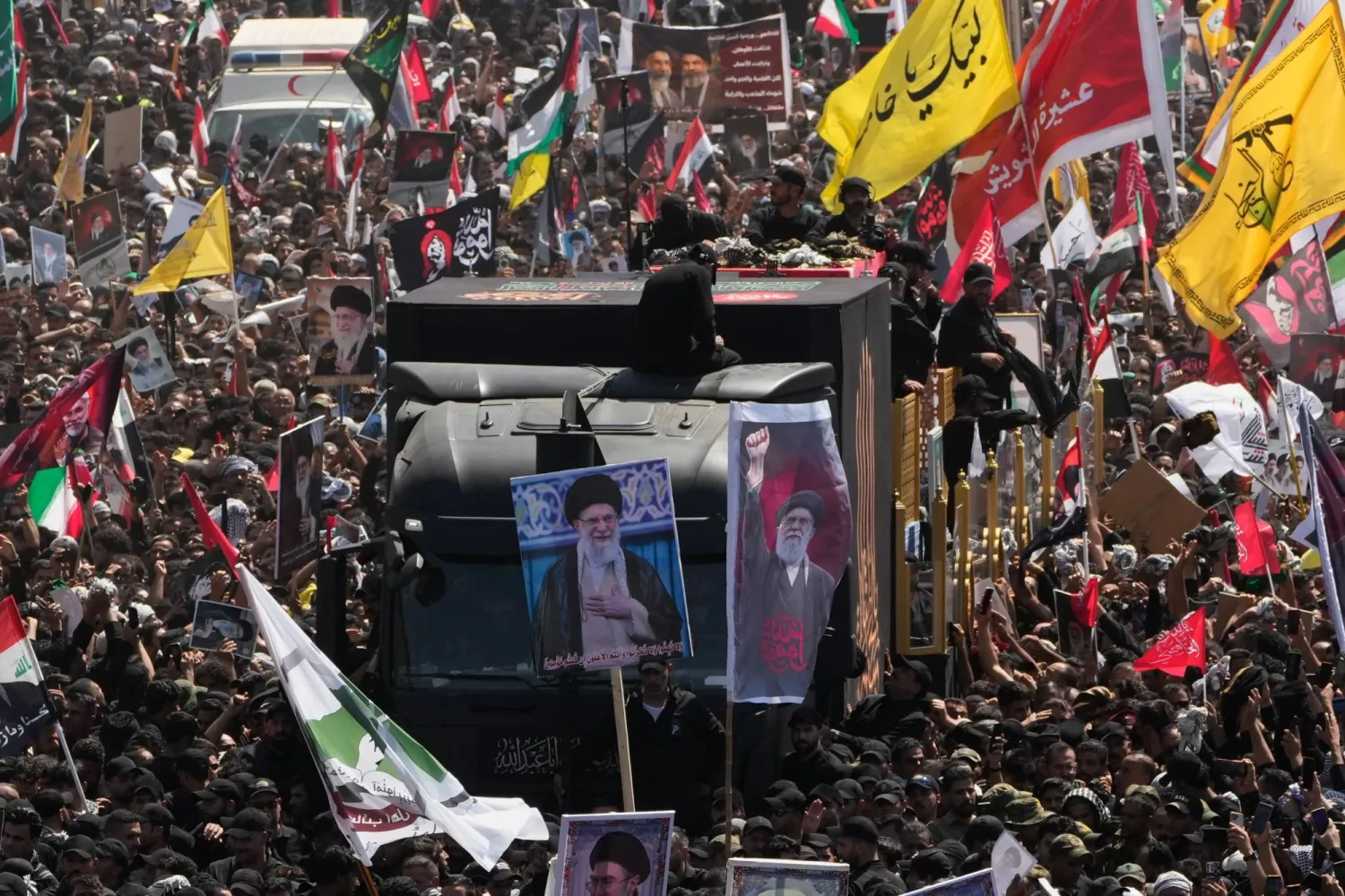 شاحنة تحمل نعش المرشد الإيراني السابق علي خامنئي تشق طريقها عبر حشود المعزين خلال موكب الجنازة في النجف العراقية (أ.ب)