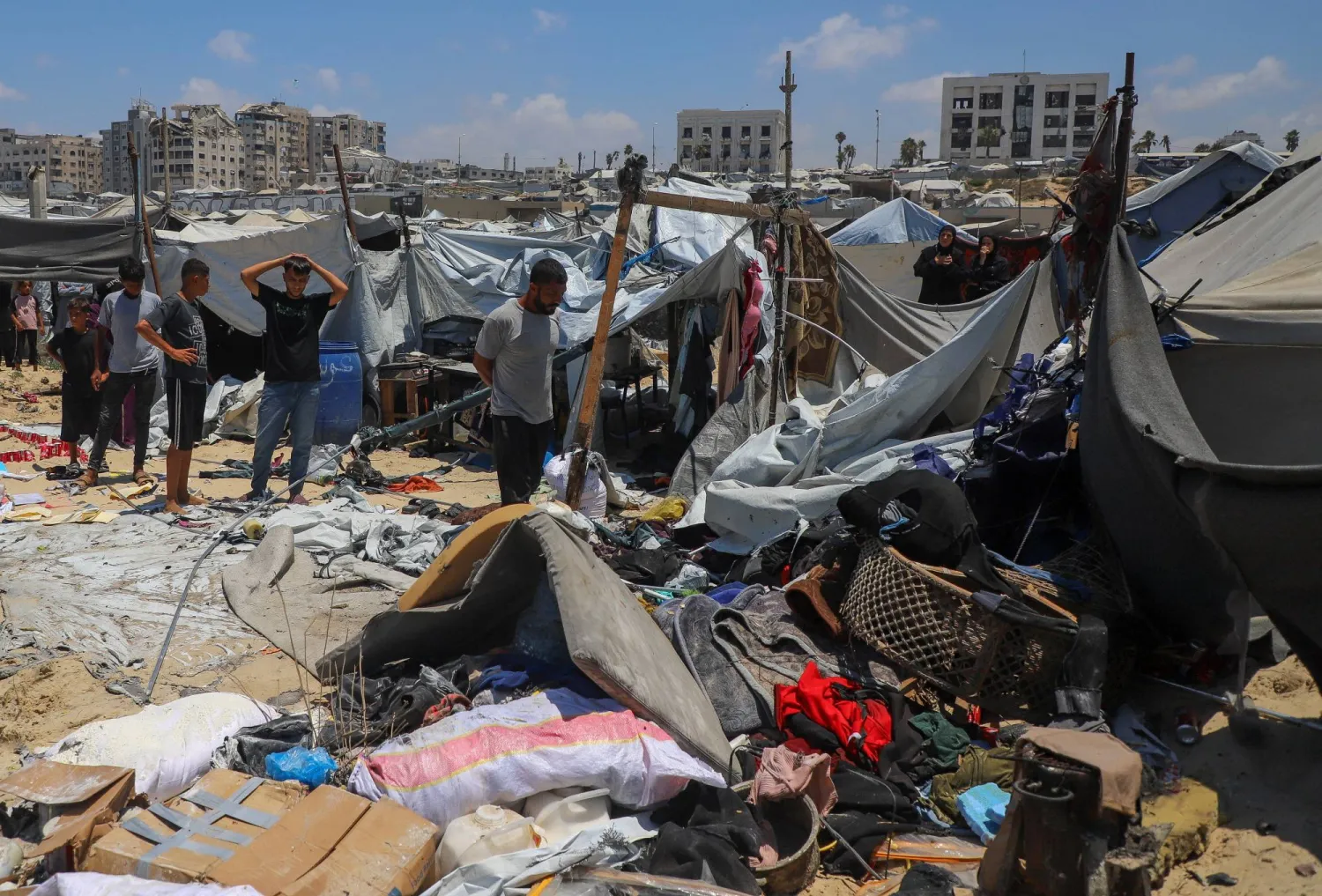 فلسطينيون يتفقدون موقع غارة إسرائيلية استهدفت خيمة في مخيم لإيواء النازحين بمدينة غزة (رويترز)
