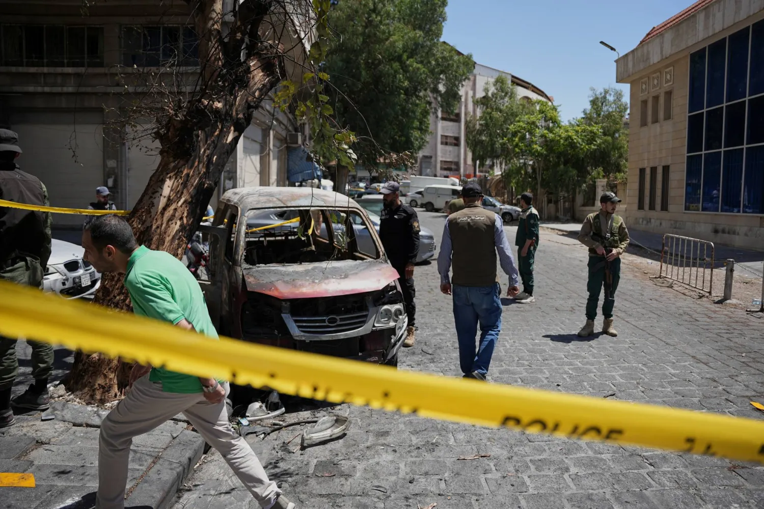 Syrian security personnel inspect a burned vehicle near the Four Seasons Hotel after two explosions rocked the area earlier in Damascus, Syria, Tuesday, July 7, 2026. (AP Photo/Omar Albam)