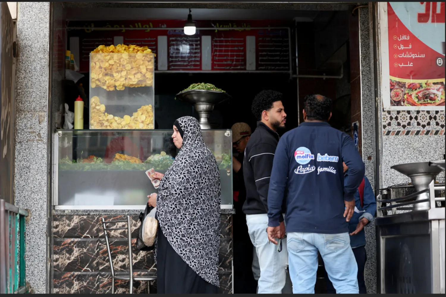 مصرية تشتري طعام الإفطار من أحد المطاعم في القاهرة (رويترز)