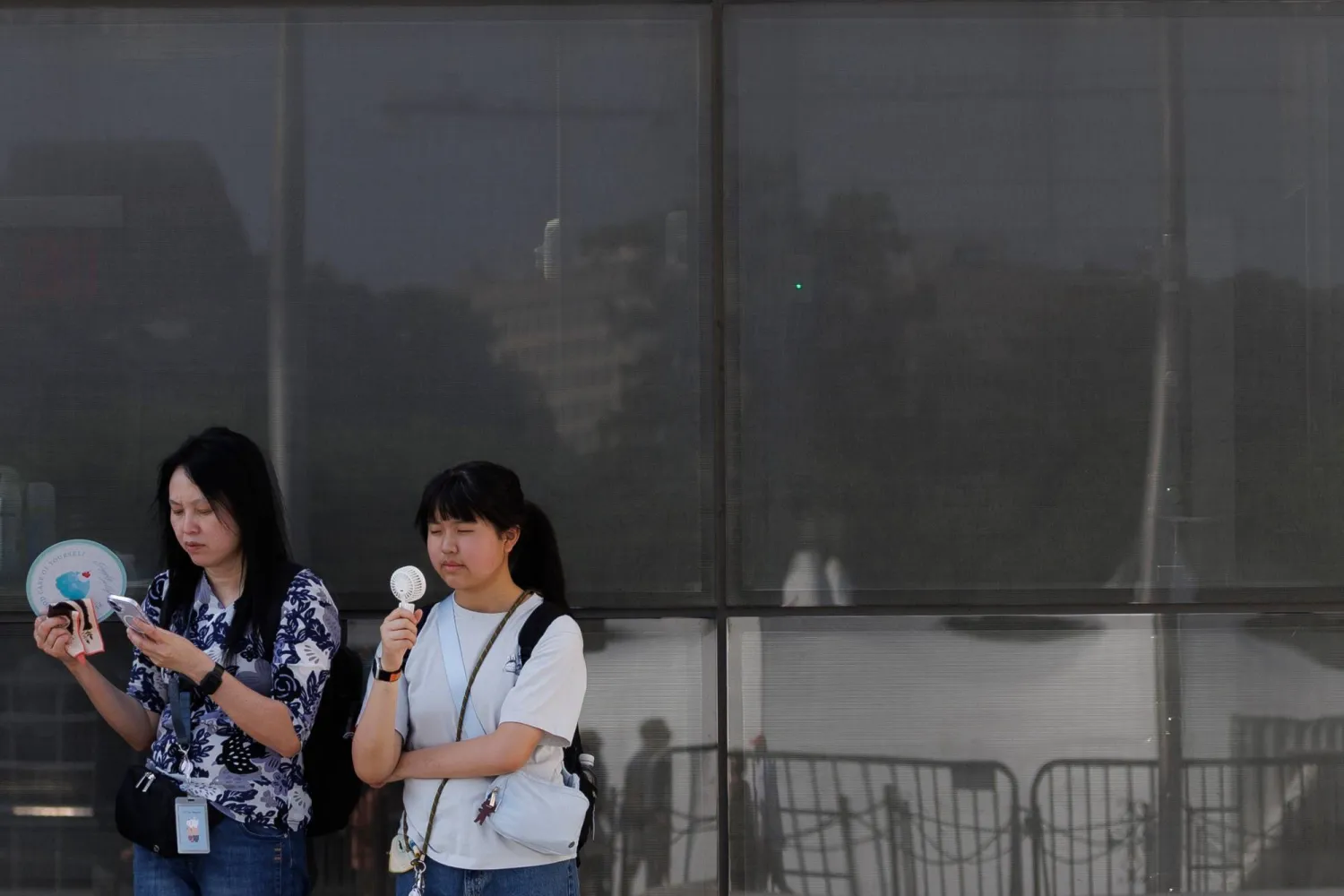 Visitors use fans as as they wait to enter the Washington Monument, July 1, 2026, in Washington. (AP) 