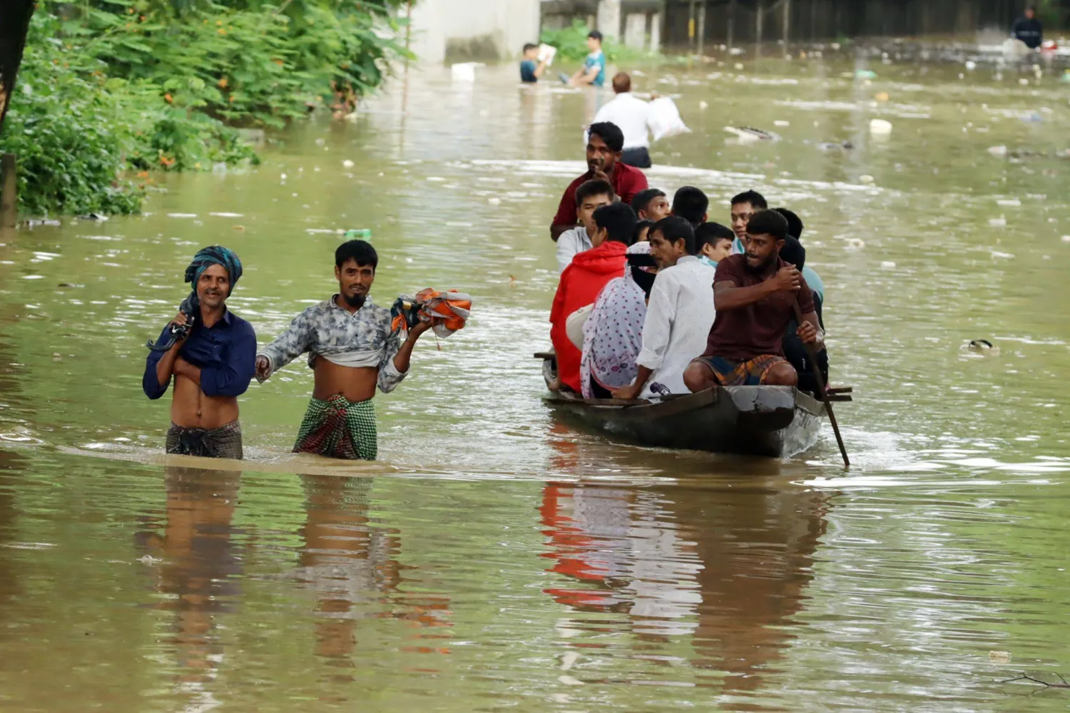 11 July 2026, Bangladesh, Dhaka: People wade through floodwaters in Dhaka, after torrential rain caused severe flooding and waterlogging across parts of the country. (dpa) 