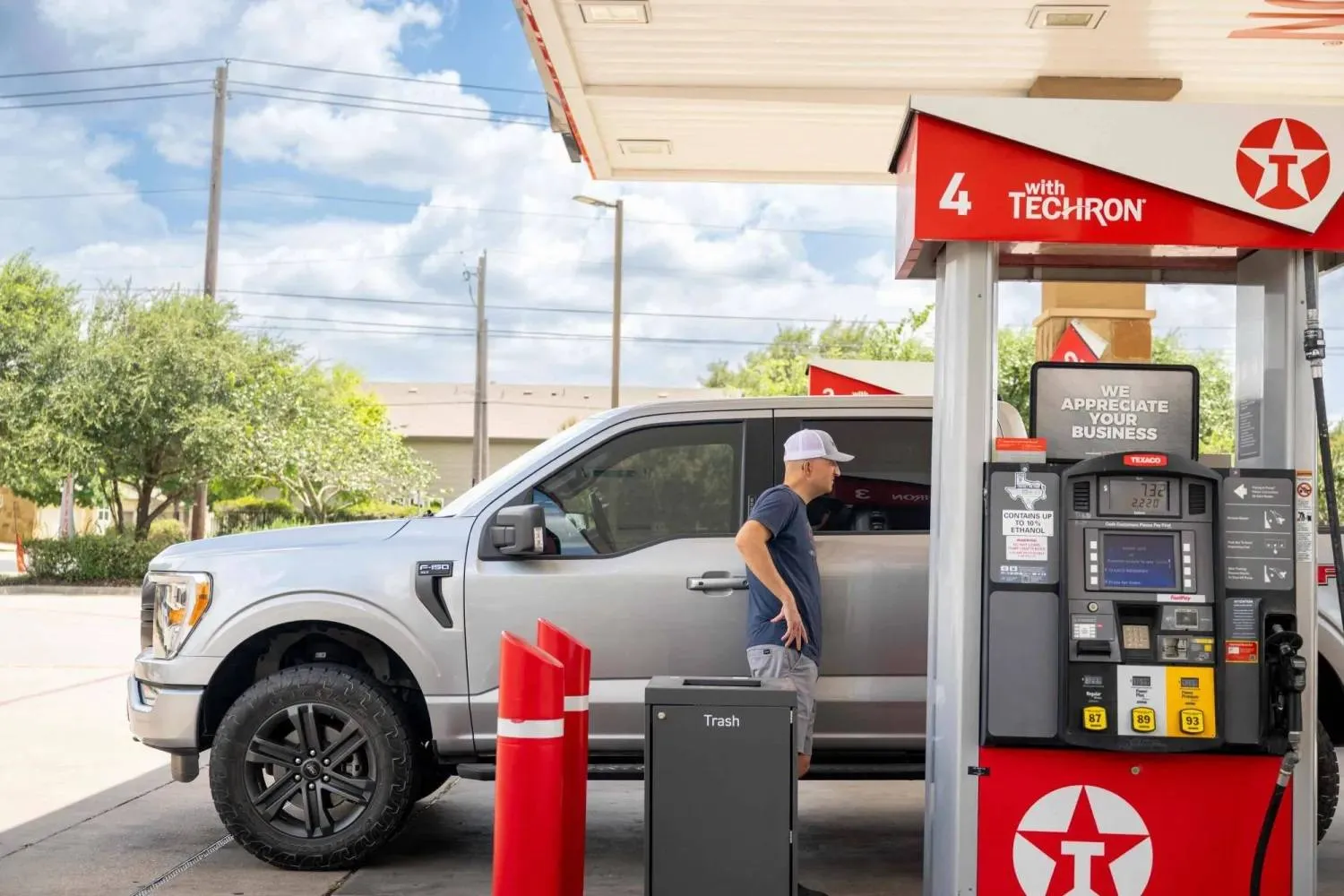 A man stands near his car at a gas station in Austin, Texas - July 10, 2026 (AFP)