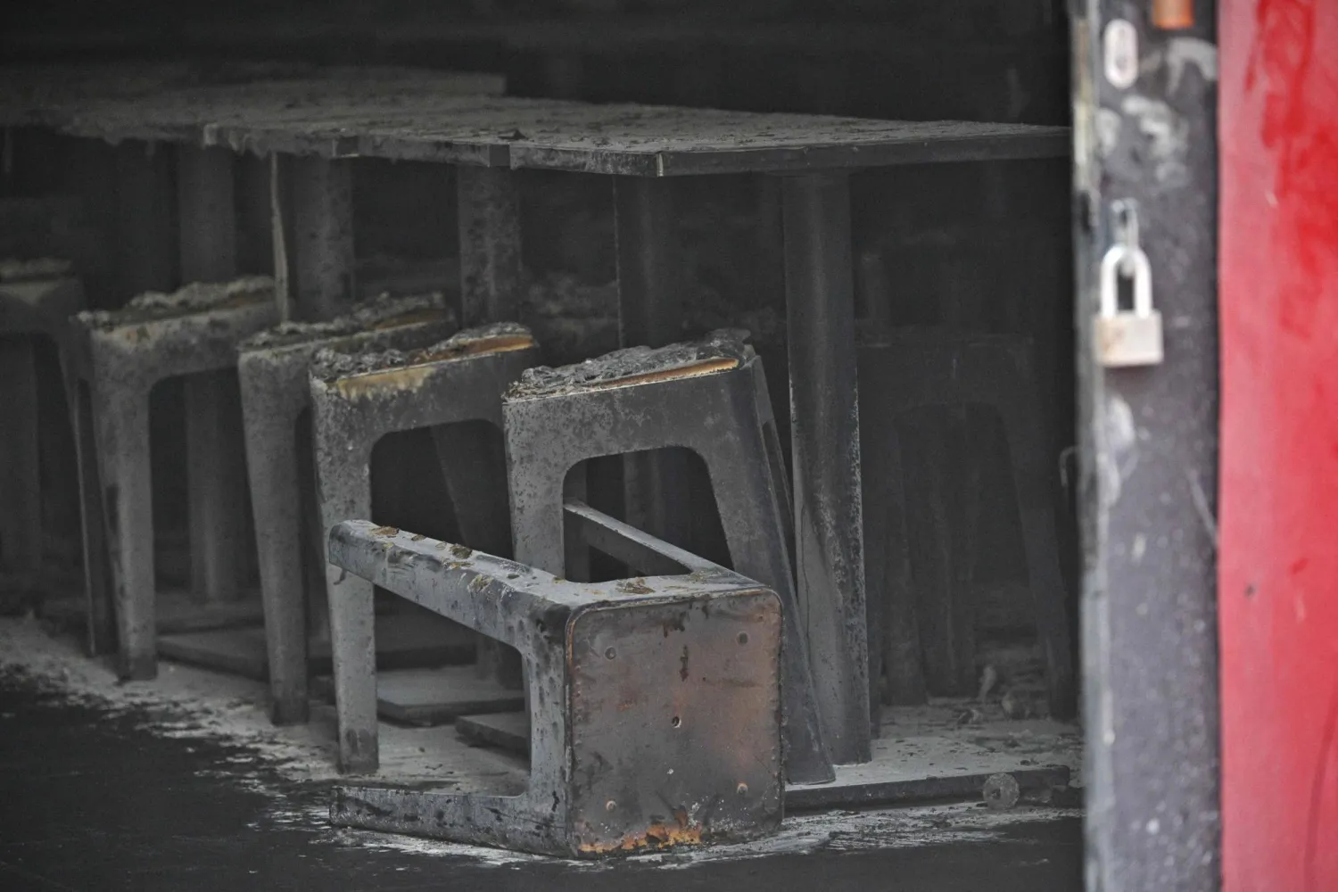 Tables and chairs are covered in ash in the aftermath of a fire at the Rong Beer Na Lat Phrao bar in Bangkok on July 13, 2026. (Photo by Lillian SUWANRUMPHA / AFP)
