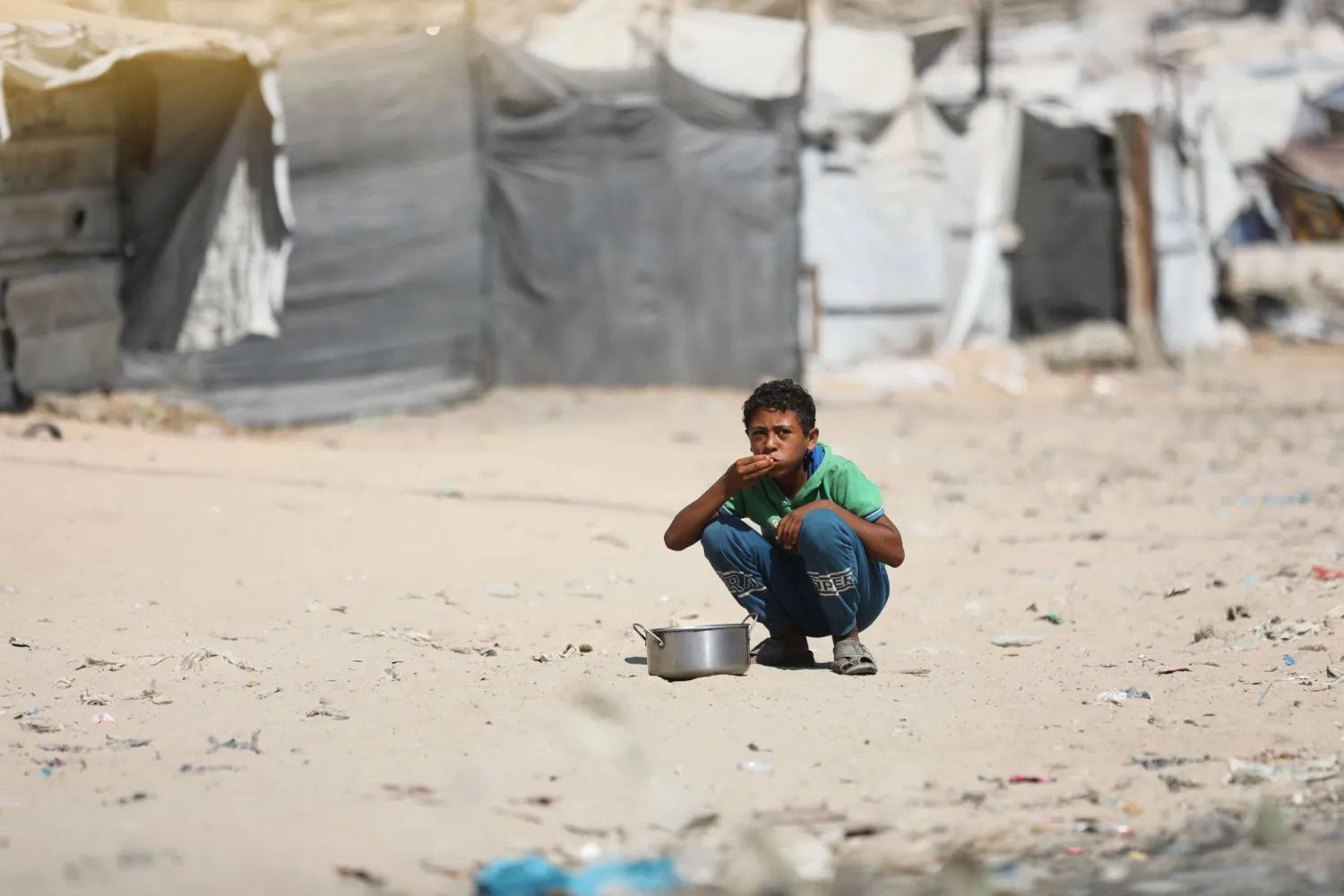 طفل فلسطيني نازح يتناول الطعام في منطقة الزرقاء بمدينة غزة وسط أزمة النزوح المستمرة ونقص الإمدادات الإنسانية الناجم عن الحرب (د.ب.أ)