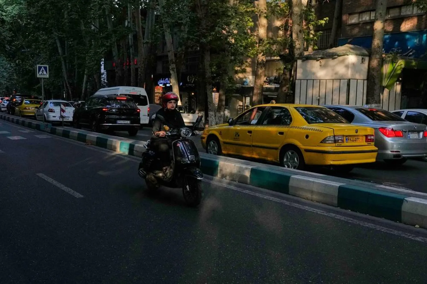  A woman rides on her scooter on a street in northern Tehran, Iran, Monday, July 13, 2026. (AP) 
