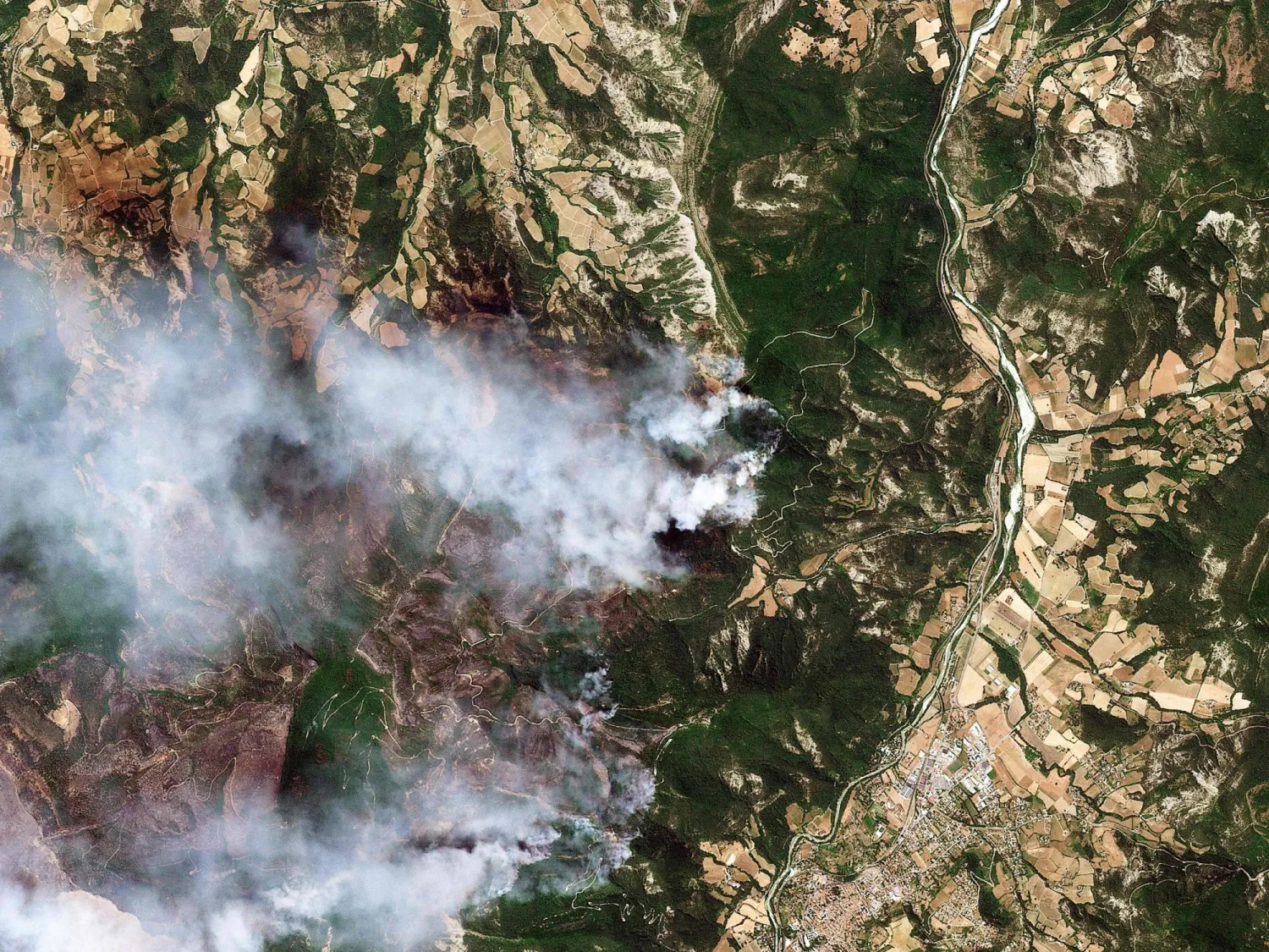 This handout satellite photograph taken on July 8, 2026 and released by 2026 Planet Labs PBC shows the smoke from a wildfire in a mountainaera near Die, southern France. (Photo by Handout / 2026 Planet Labs PBC / AFP)