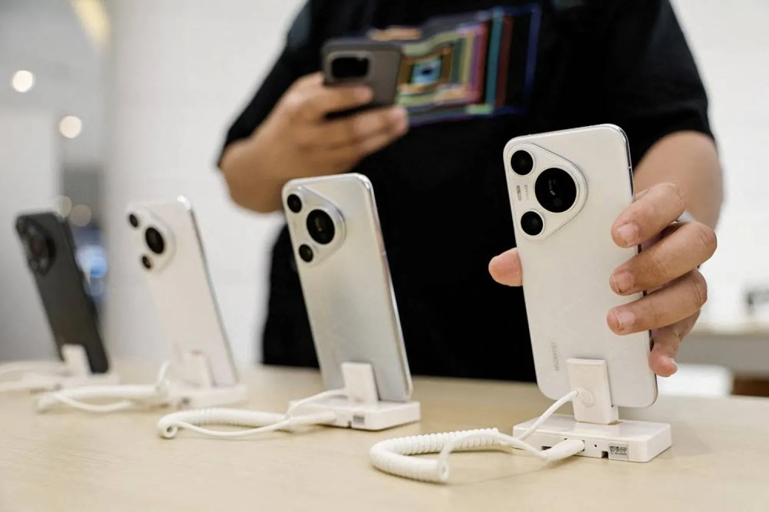 A customer looks at a new Huawei Pura 70 series smartphone, as the series models go on sale at a Huawei's flagship store in Beijing, China April 18, 2024. (Reuters) 