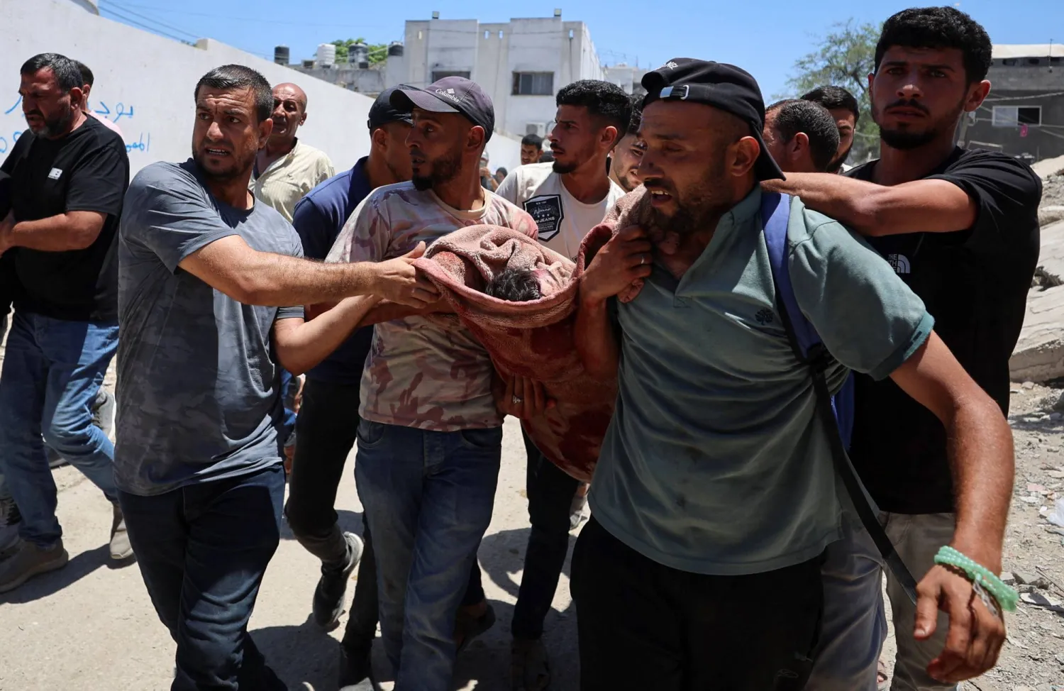 فلسطينيون خارج مستشفى الشفاء في مدينة غزة يحملون جثمان أحد الضباط الفلسطينيين الذين قتلوا في غارة إسرائيلية على مركز للشرطة(رويترز)