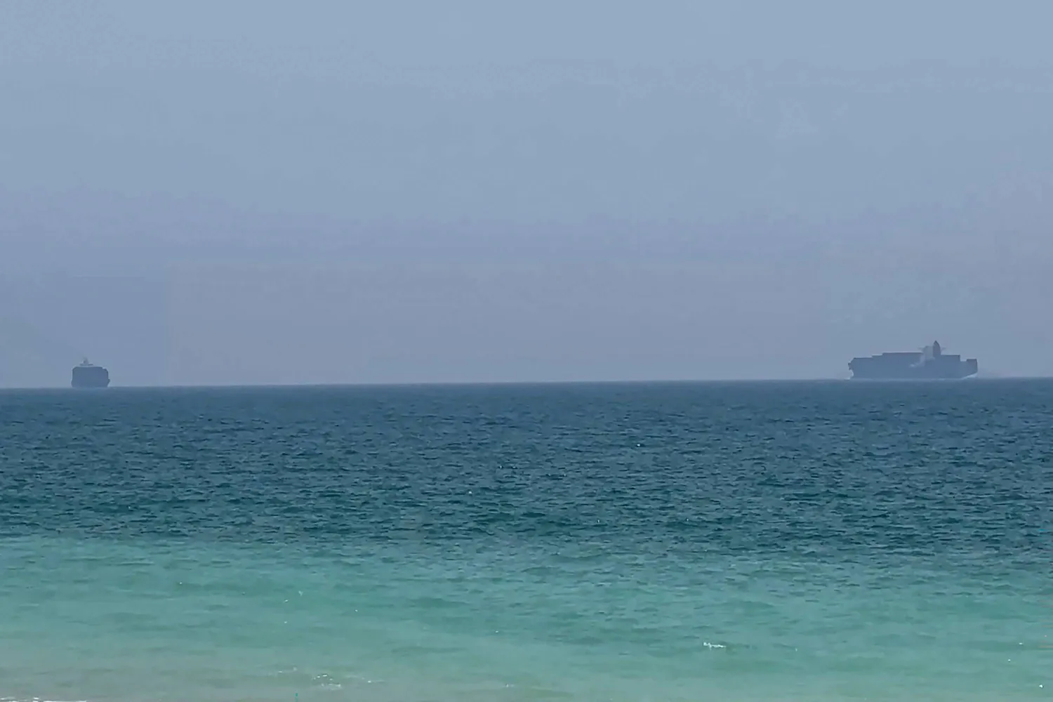 This frame grab taken from AFPTV video footage on July 12, 2026 shows cargo ships anchoring near the Strait of Hormuz off the eastern coast of the United Arab Emirates at Khor Fakkan.(AFPTV/AFP)