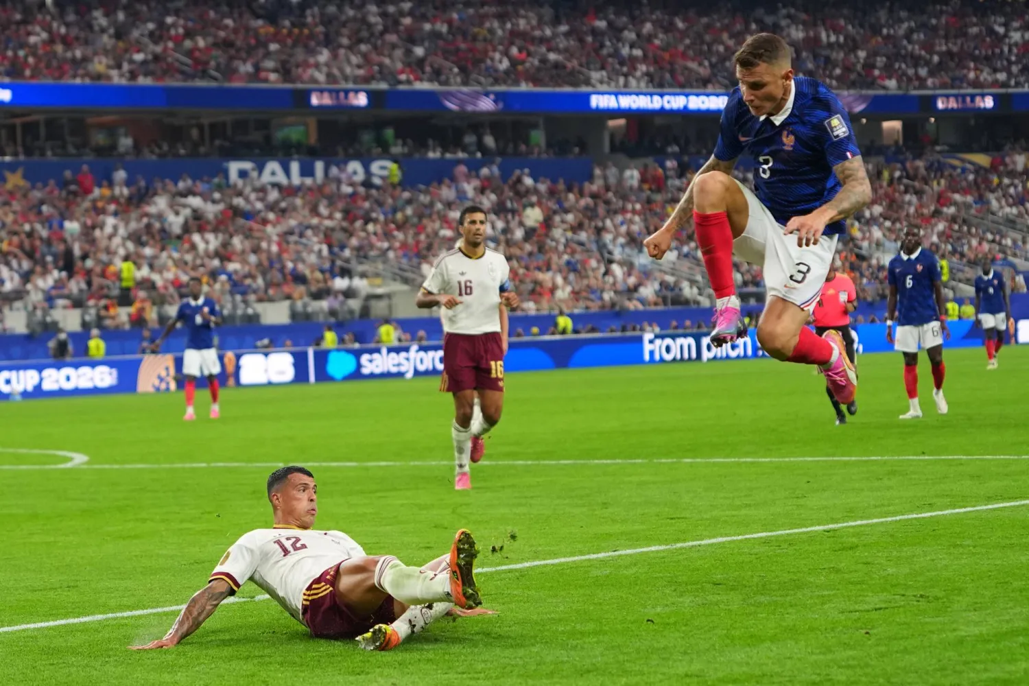 الفرنسي لوكاس ديني يقفز بينما يُبعد الإسباني بيدرو بورو الكرة (أ.ب) 