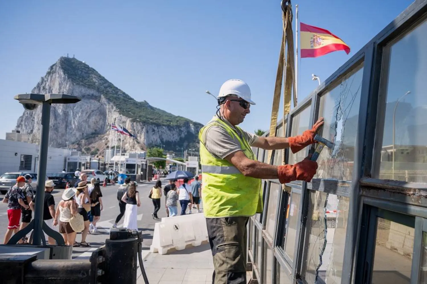  Against the backdrop of the Rock of Gibraltar, workers dismantle a Spanish border checkpoint that separated the disputed British overseas territory from Spain in La Línea de la Concepción, Spain, Monday, July 6, 2026. (AP) 
