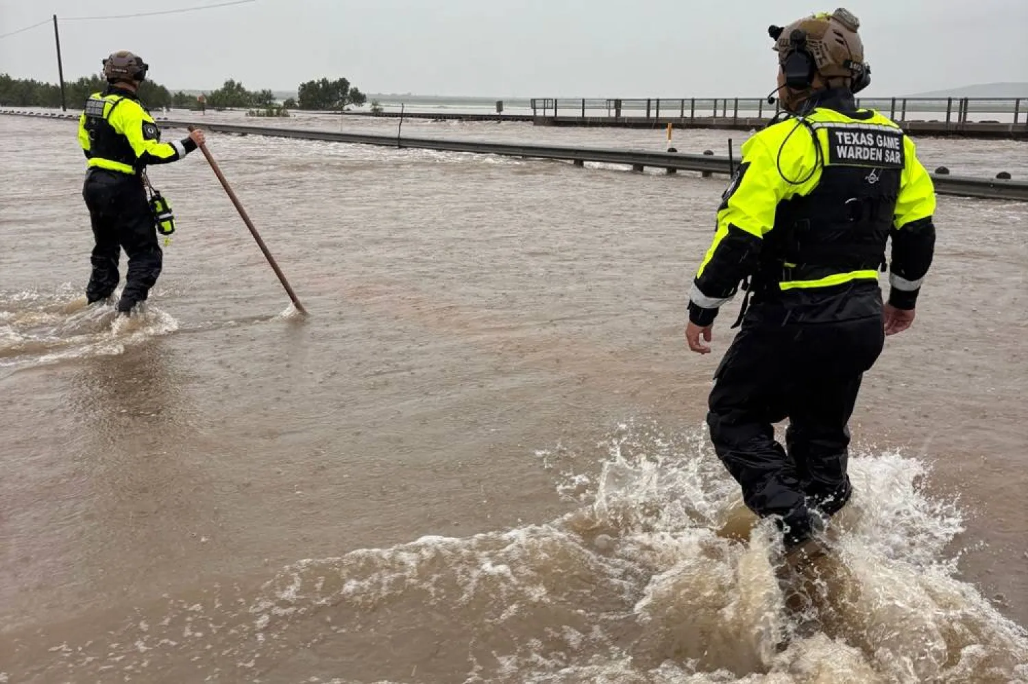  In this handout photo provided by the Texas Parks and Wildlife Department, game wardens walk through high waters from heavy rains in Uvalde County, Texas, on Tuesday, July 14, 2026. (Texas Parks and Wildlife Department via AP) 