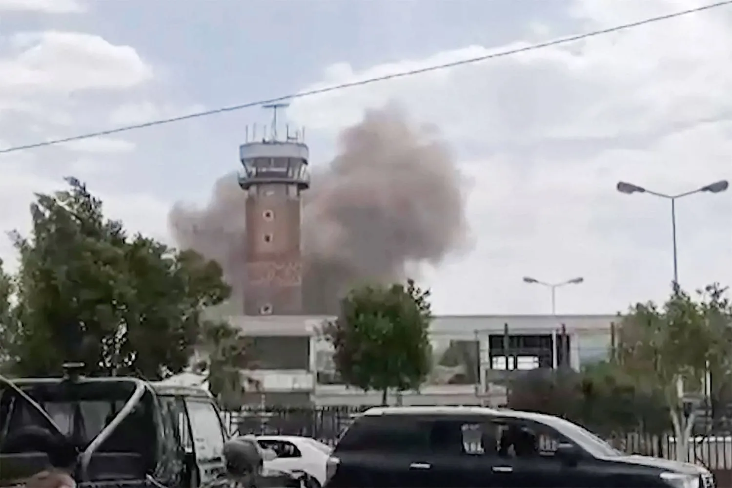 Graphic content / TOPSHOT - This screen grab taken from a video footage made available via AFPTV on July 13, 2026 shows smoke rising from the airport in Sanaa