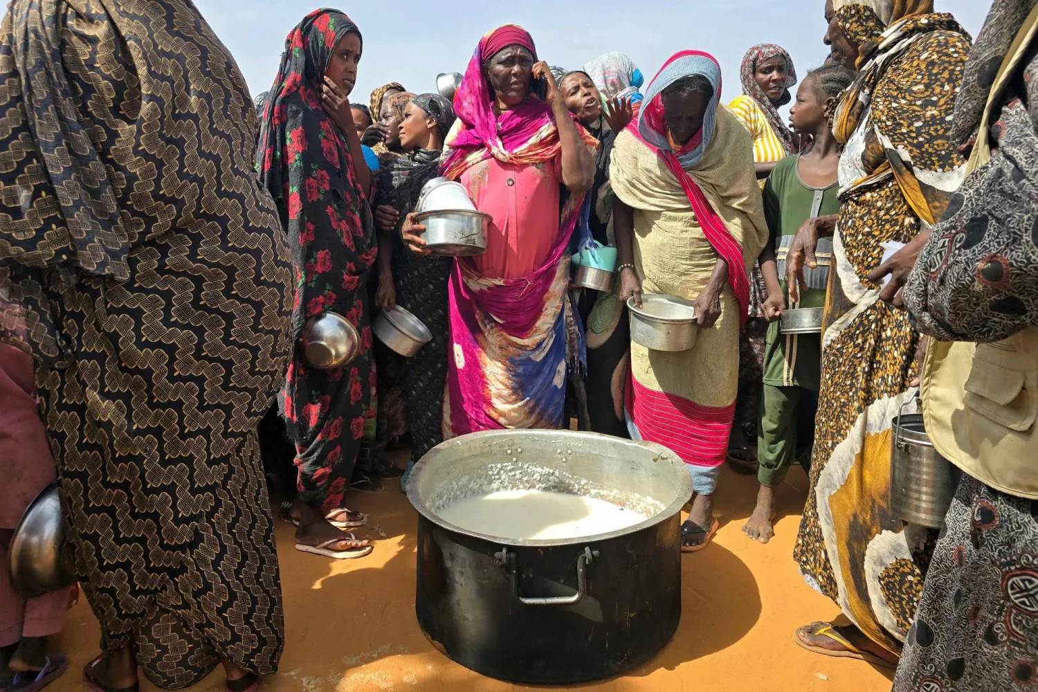 تتجمع نساء سودانيات لتناول وجبة ساخنة في مخيم الرحمانية للنازحين بالقرب من مدينة الأبيض في منطقة كردفان الجنوبية (أ.ف.ب)