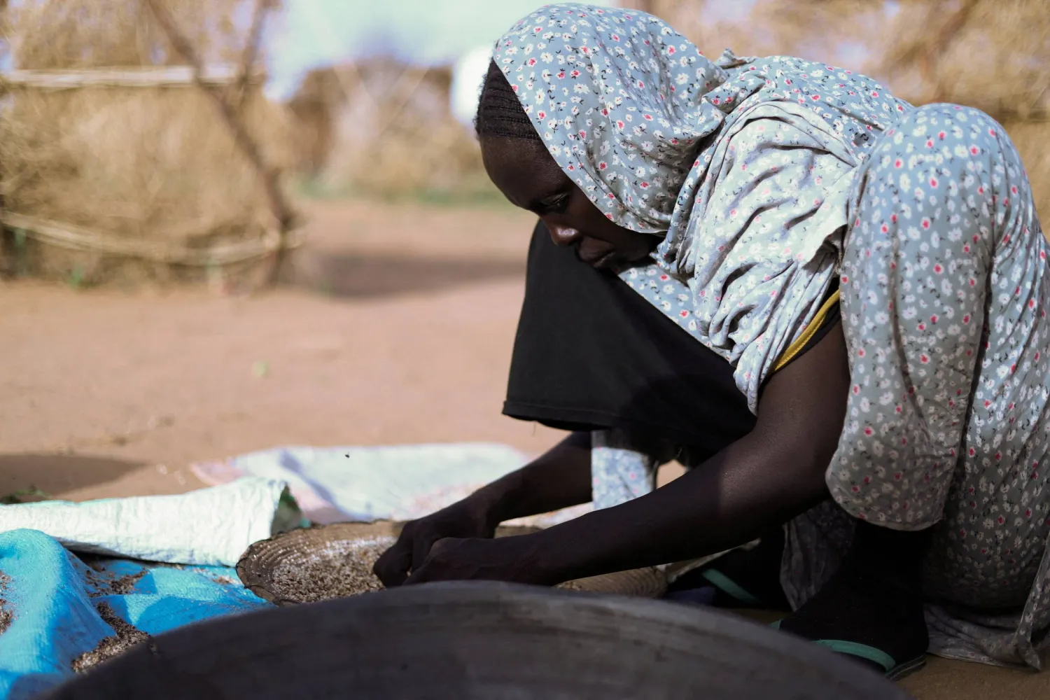 FILE PHOTO: A displaced Sudanese mother of five, including her child, prepares food at a camp shelter amid the ongoing conflict between the RSF and the Sudanese army, in Tawila, North Darfur, Sudan, July 30, 2025. REUTERS/Mohamed Jamal/File Photo