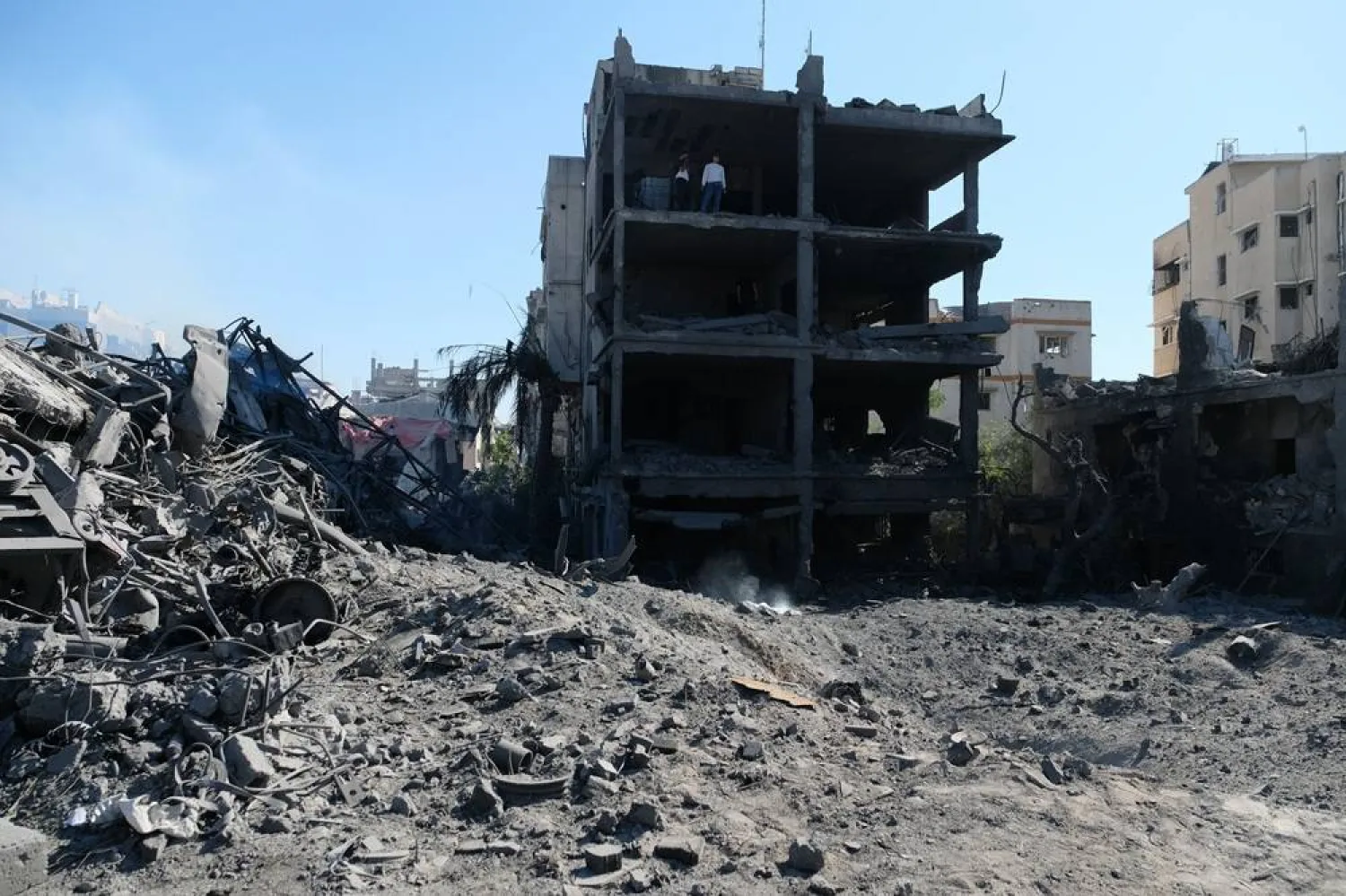  Palestinians gather around a blacksmith shop in Gaza City's Sabra neighborhood after it was hit by an Israeli military strike on Sunday, July 12, 2026. (AP) 