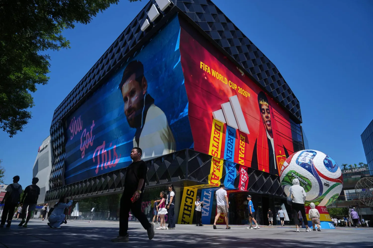 Shoppers walk by an Adidas sportswear store promoting the FIFA World Cup event at an outdoor shopping mall, in Beijing, Sunday, June 21, 2026. (AP Photo/Andy Wong)