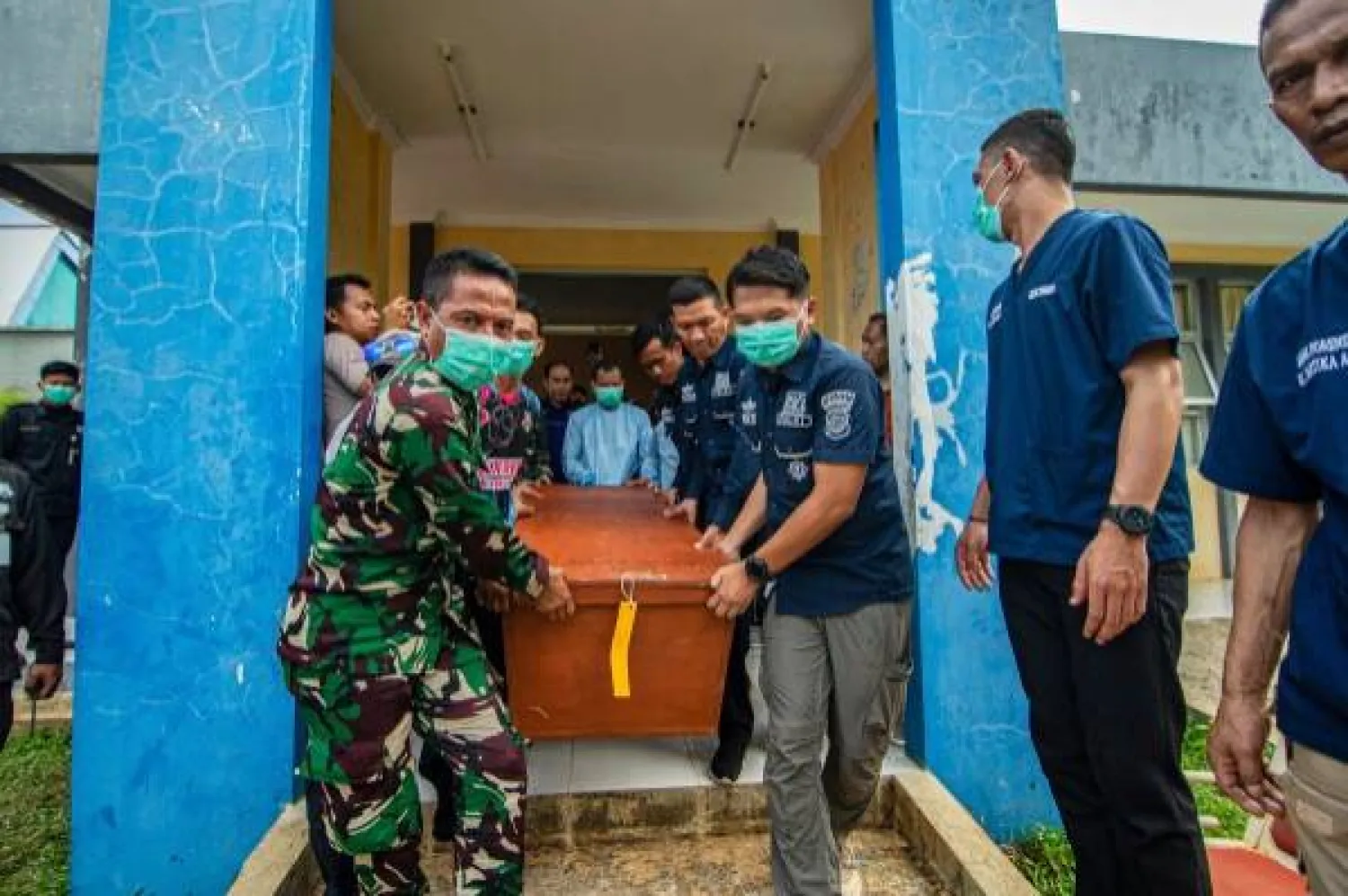 صورة أرشيفية تظهر جنوداً وشرطة إندونيسيين يحملون جثة شخص قُتل بانفجار ذخيرة (أ.ب)