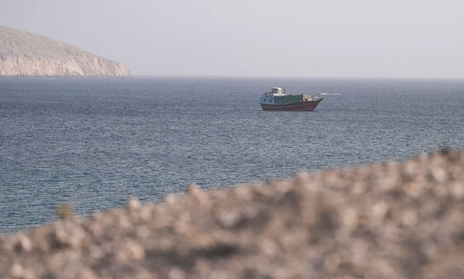 باخرة في مضيق هرمز كما تبدو من مسندم في عُمان (رويترز)