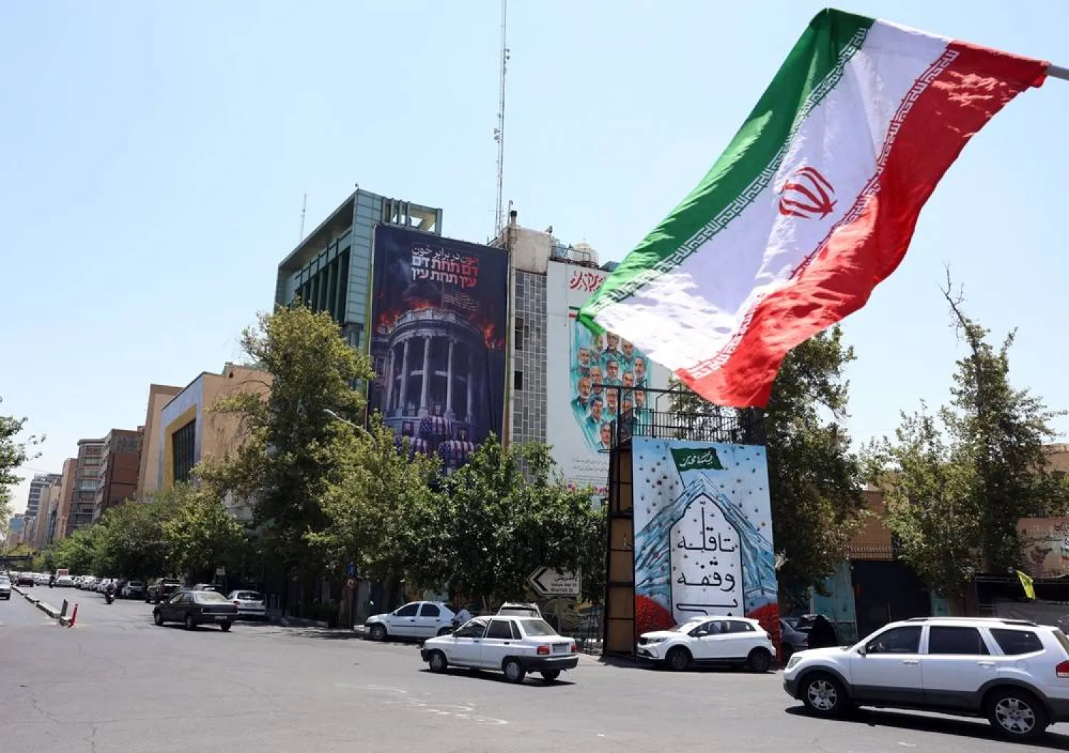 Iranians drive past an anti-US billboard featuring pictures of US President Donald Trump and his family on top of US flag-draped coffins, accompanied by a sentence in Persian that reads "Blood for Blood," that hangs at Palestine Square in Tehran, Iran, 16 July 2026. (EPA)
