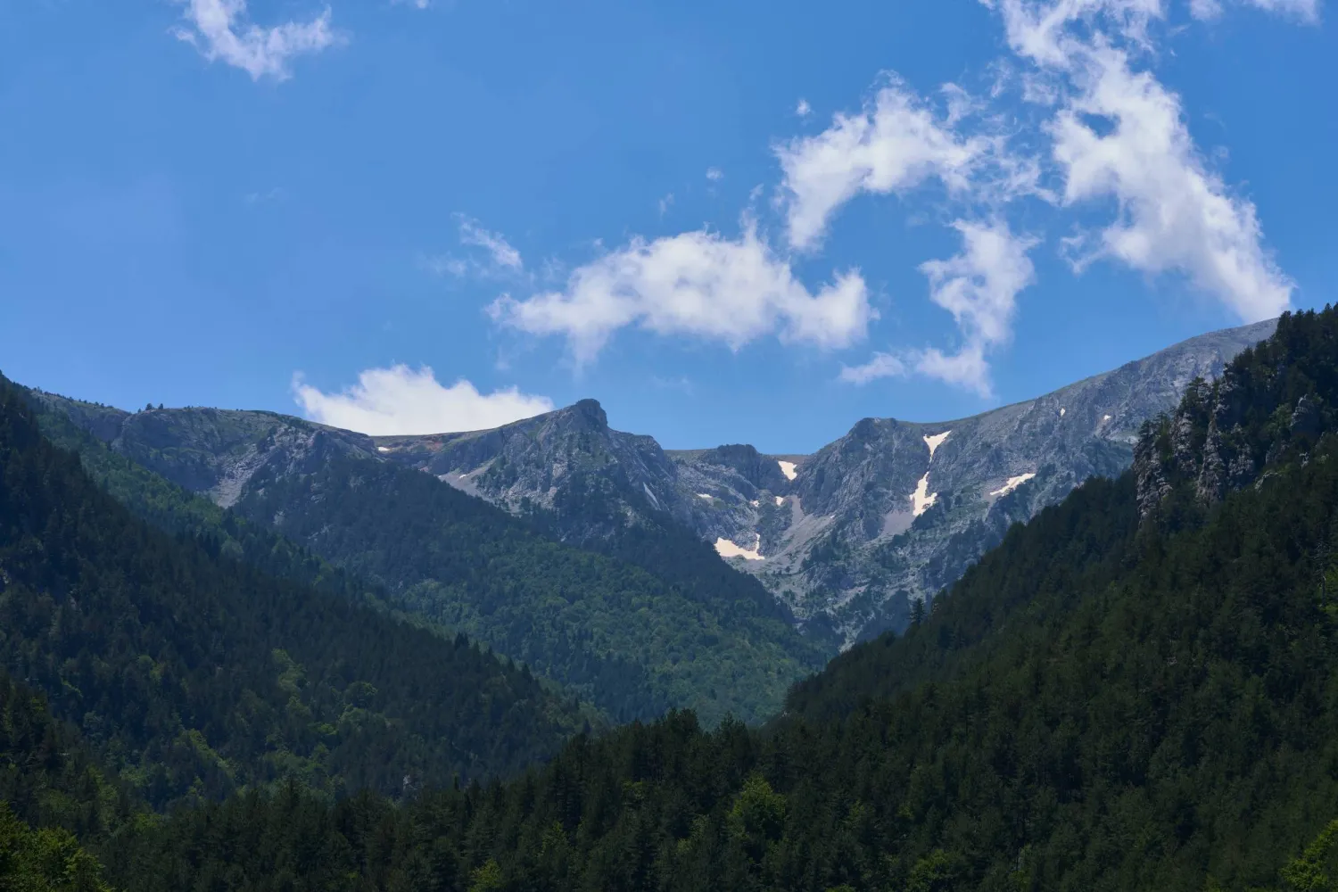 Snow patches remain on the upper slopes of Mount Olympus in northern Greece, Tuesday, July 14, 2026. (AP Photo/Petros Giannakouris)