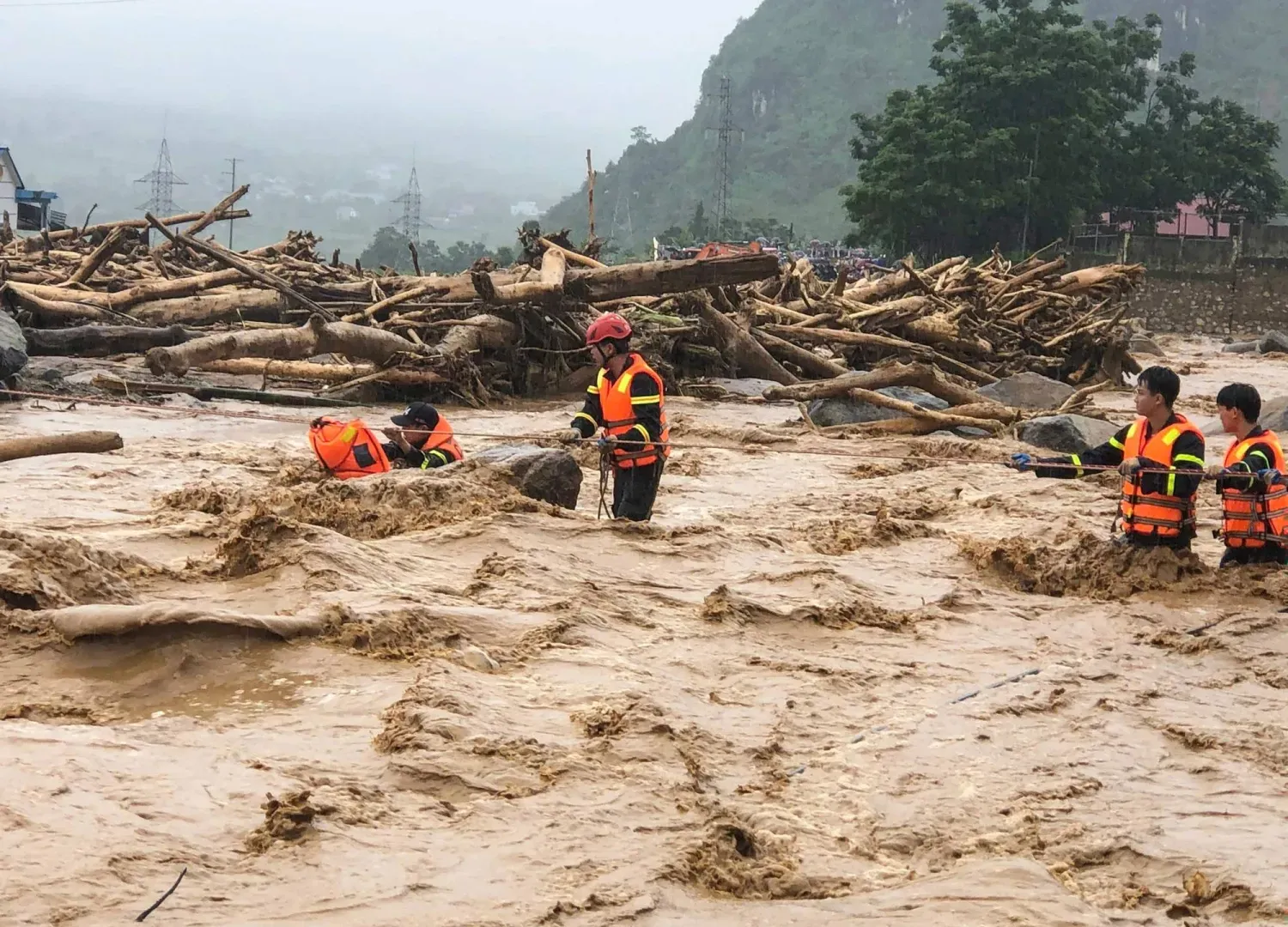 Kurtarma ekipleri, Vietnam'ın kuzeyindeki Muong Thanh bölgesinde sel gibi akan çamurun ortasında çalışıyor (AFP)