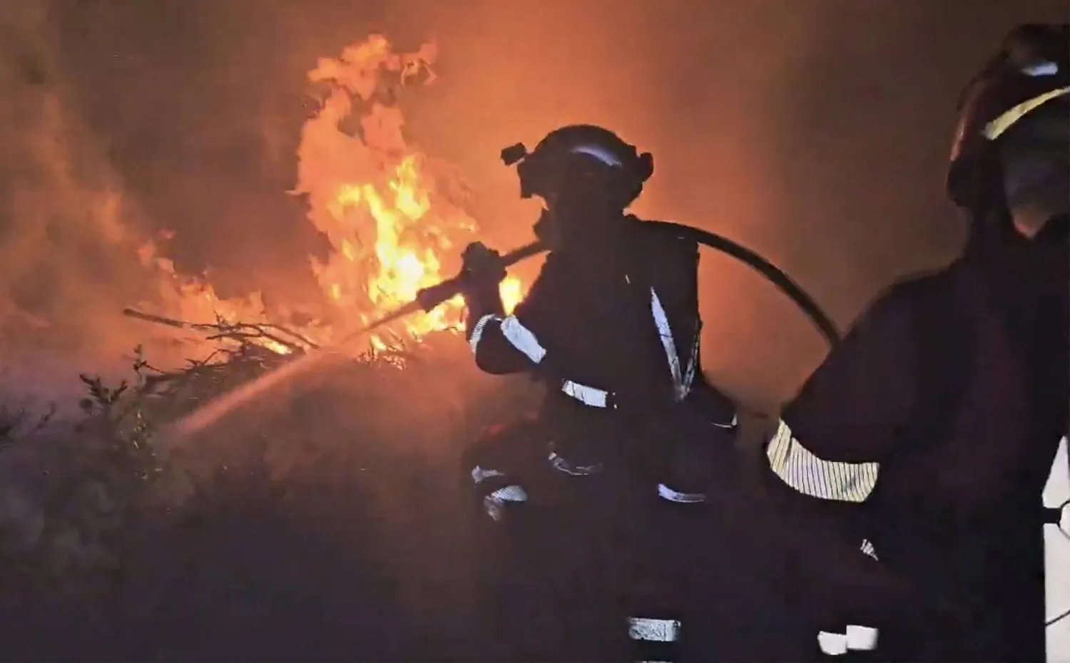 This screen grab taken from handout video footage released on July 18, 2026 by Spain's Military Emergencies Unit (UME) shows the military fighting a massive wildfire, in Luesia area, in a sparsely populated part of the Aragon region in northeastern Spain. (Photo by Handout / UME / AFP)