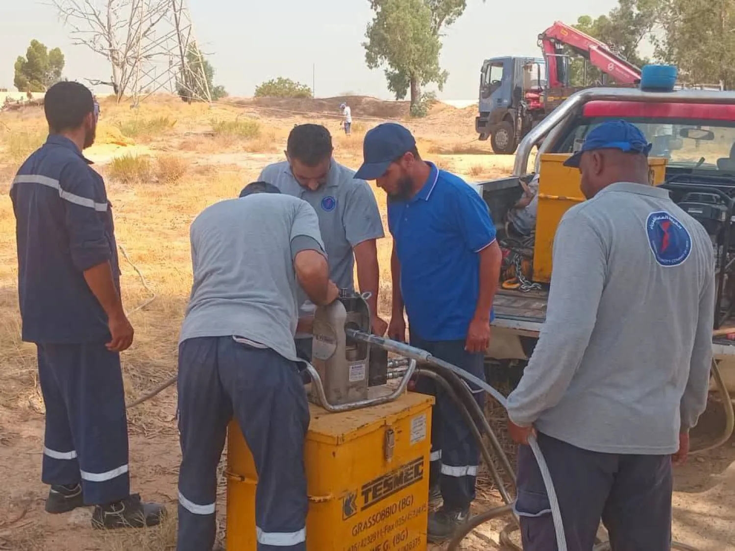 فنيو الشركة العامة للكهرباء في ليبيا خلال عملية صيانة على أحد الخطوط بطرابلس يوم الأحد (الشركة)