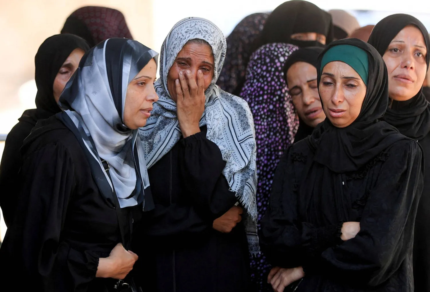 فلسطينيات يبكين يوم الأحد خلال جنازة ضحايا غارة إسرائيلية على مدينة غزة (رويترز)