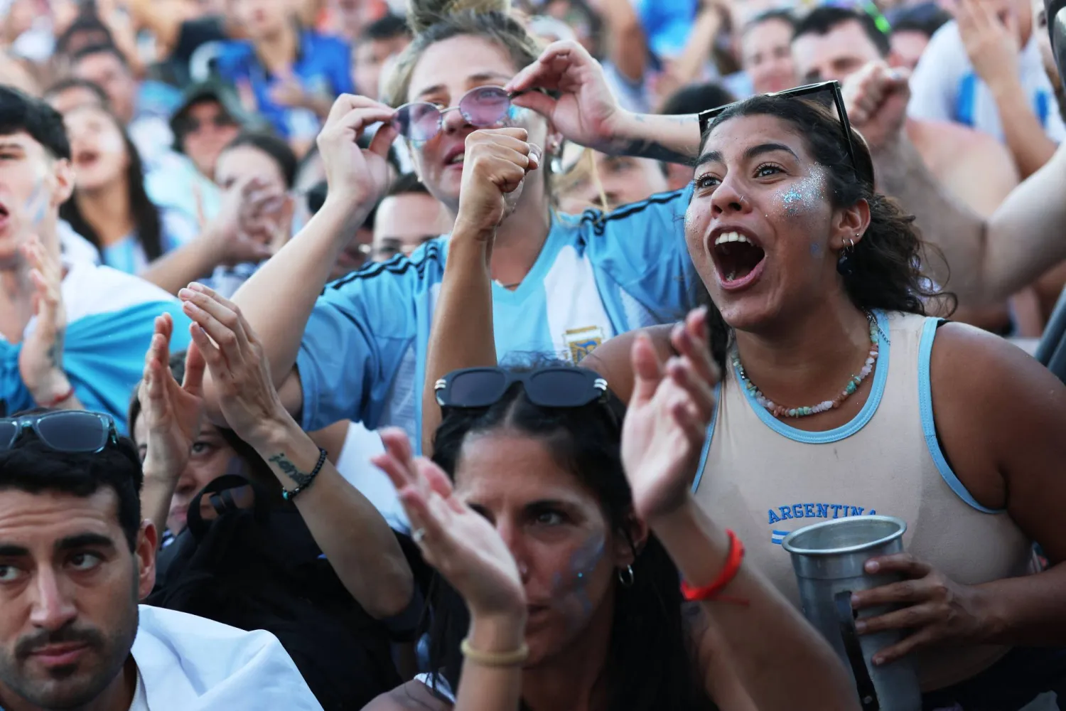  مشجعو الأرجنتين يتفاعلون أثناء مشاهدة المباراة النهائية لكأس العالم بين إسبانيا والأرجنتين على شاطئ كوباكابانا (رويترز) 