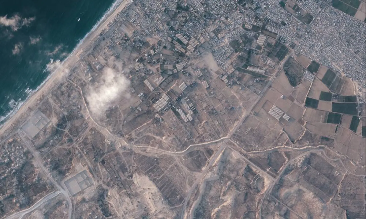 A satellite image from Planet Labs PBC shows a section of an earthen barrier, cutting horizontally across the middle of the image, being built by the Israeli military in the southern Gaza Strip, July 15, 2026. On one side are two military bases, and on the other the Palestinian tent city of Muwasi. (Planet Labs PBC via AP) 