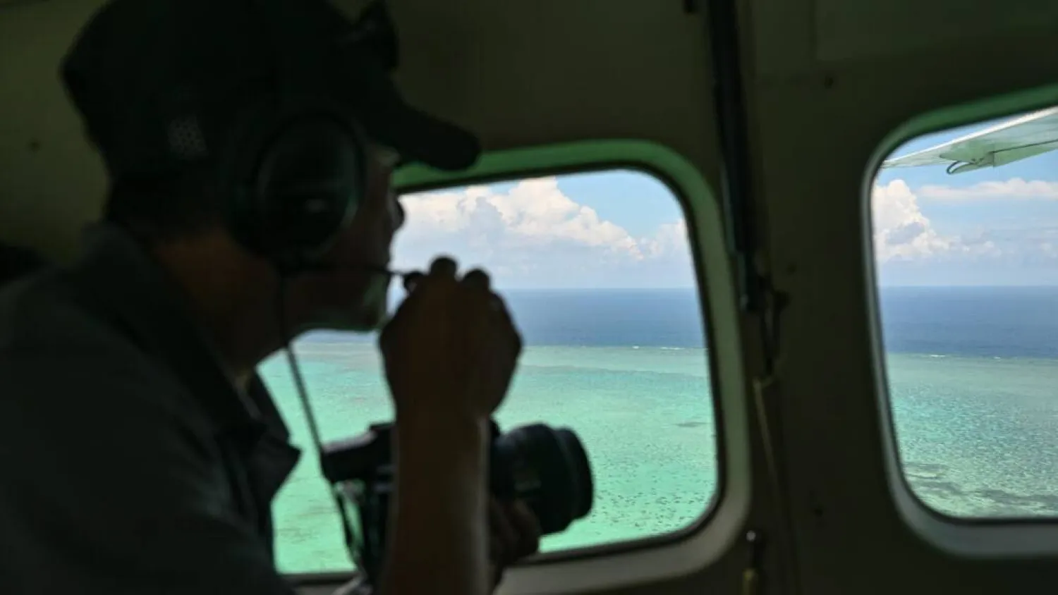 A Philippine Coast Guard personnel talks on a mic as he looks over Scarborough Shoal in the disputed South China Se. Jam STA ROSA / AFP

