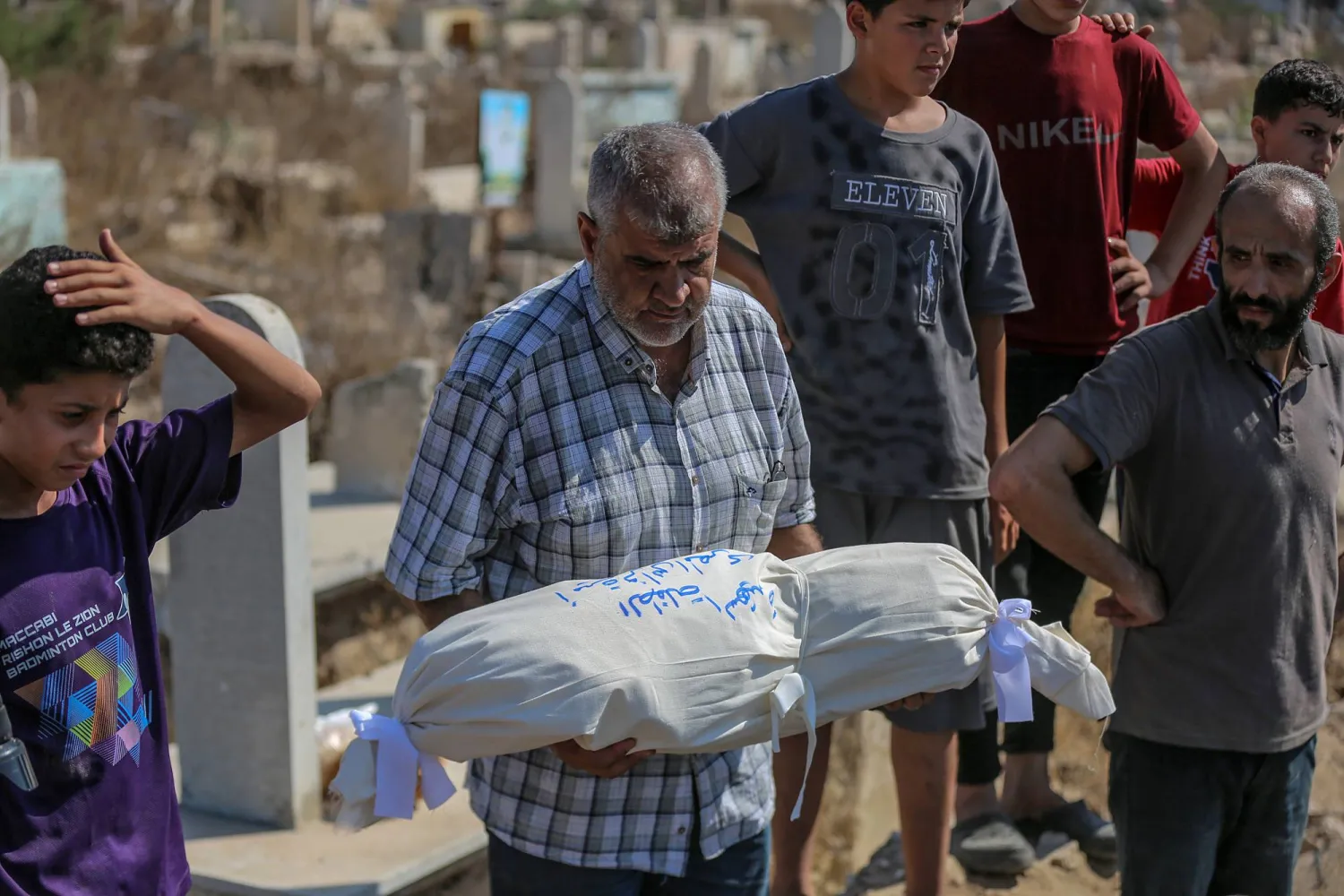 أقارب فلسطينيون من عائلة المصري يحيون مراسم دفنهم في مقبرة بمدينة غزة (إ.ب.أ)