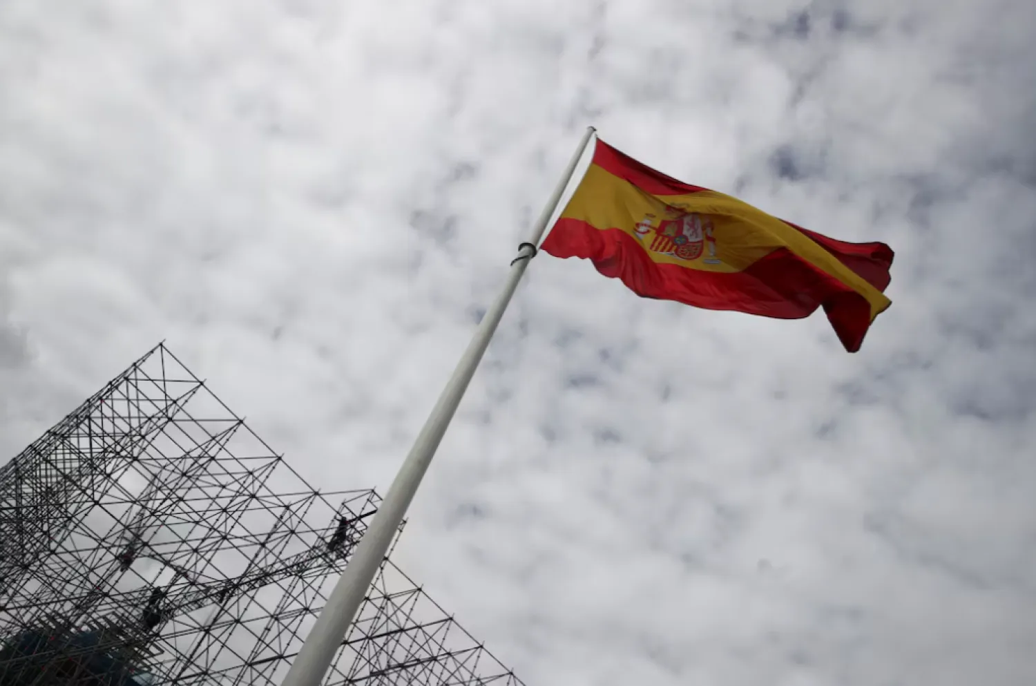 Workers set up a huge scaffold as a Spanish flag flutters at the Colon square in Madrid, Spain, November 2, 2021. REUTERS/Sergio Perez